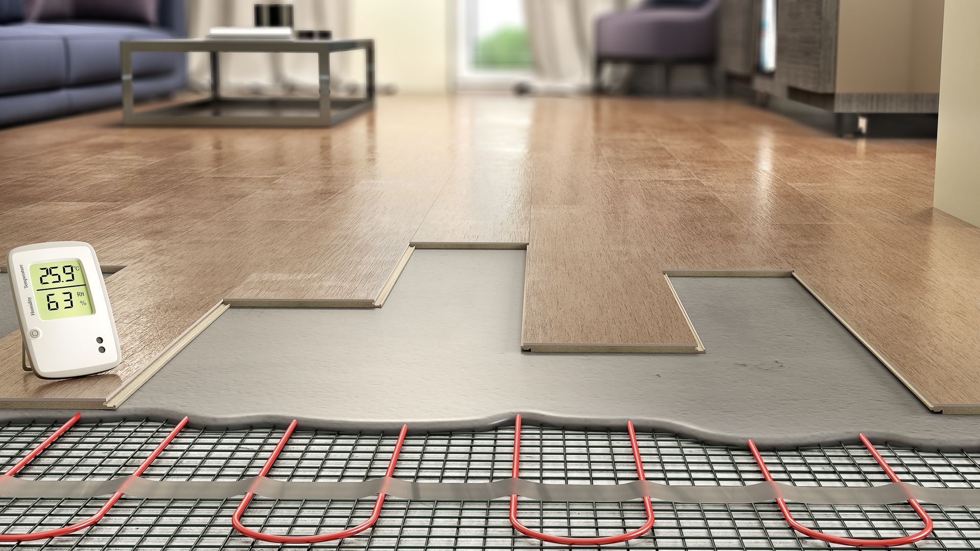 Installation of floor heating system: red pipes on mesh, gray underlayment, and wood flooring.