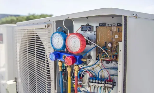 A close up of an air conditioner with two gauges attached to it.