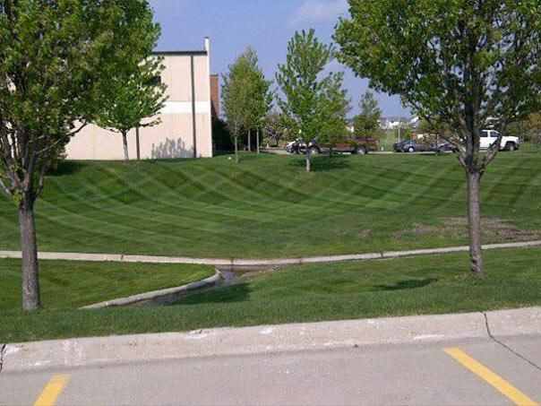 A large white house with a lush green lawn in front of it.