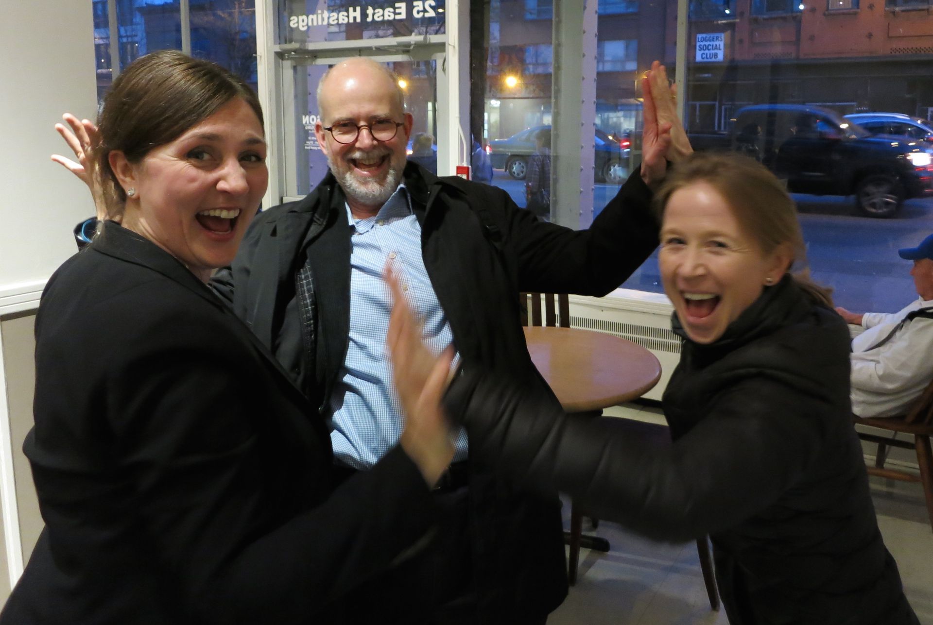 April Rinne, a man and another woman are giving each other a high five