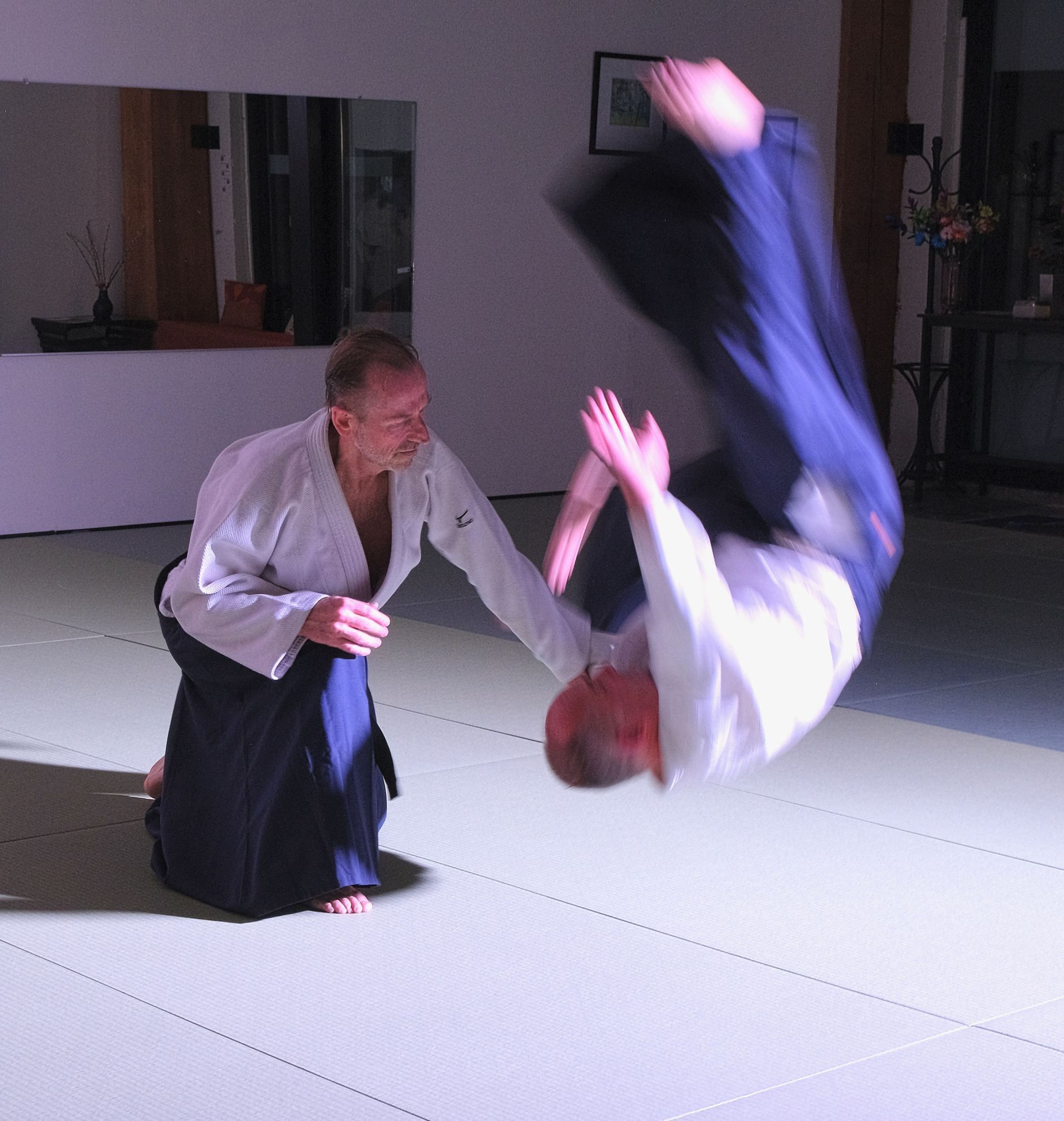 Jerry Michalski and another man are practicing martial arts in front of a mirror