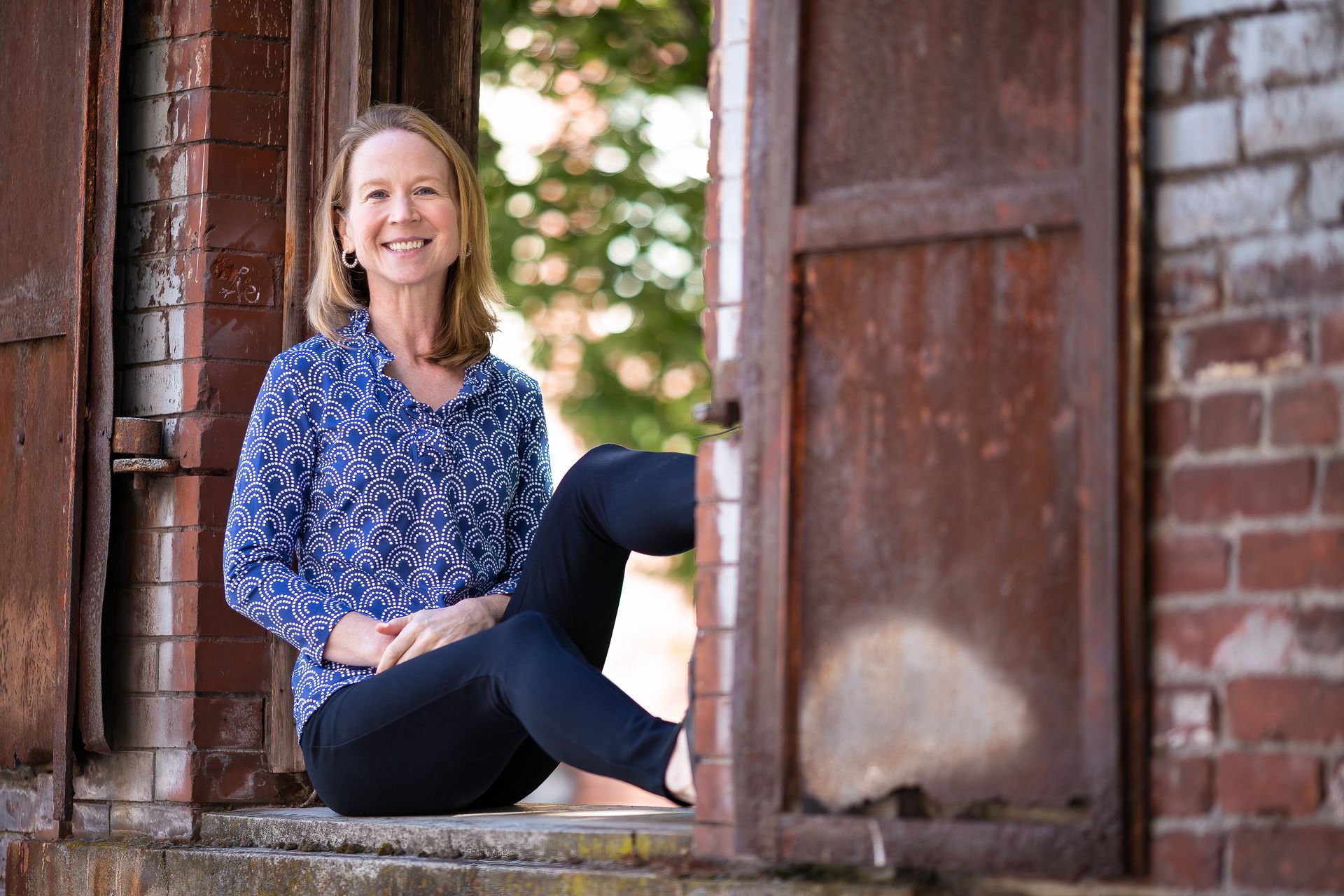 April Rinne is sitting on the steps of an old building.