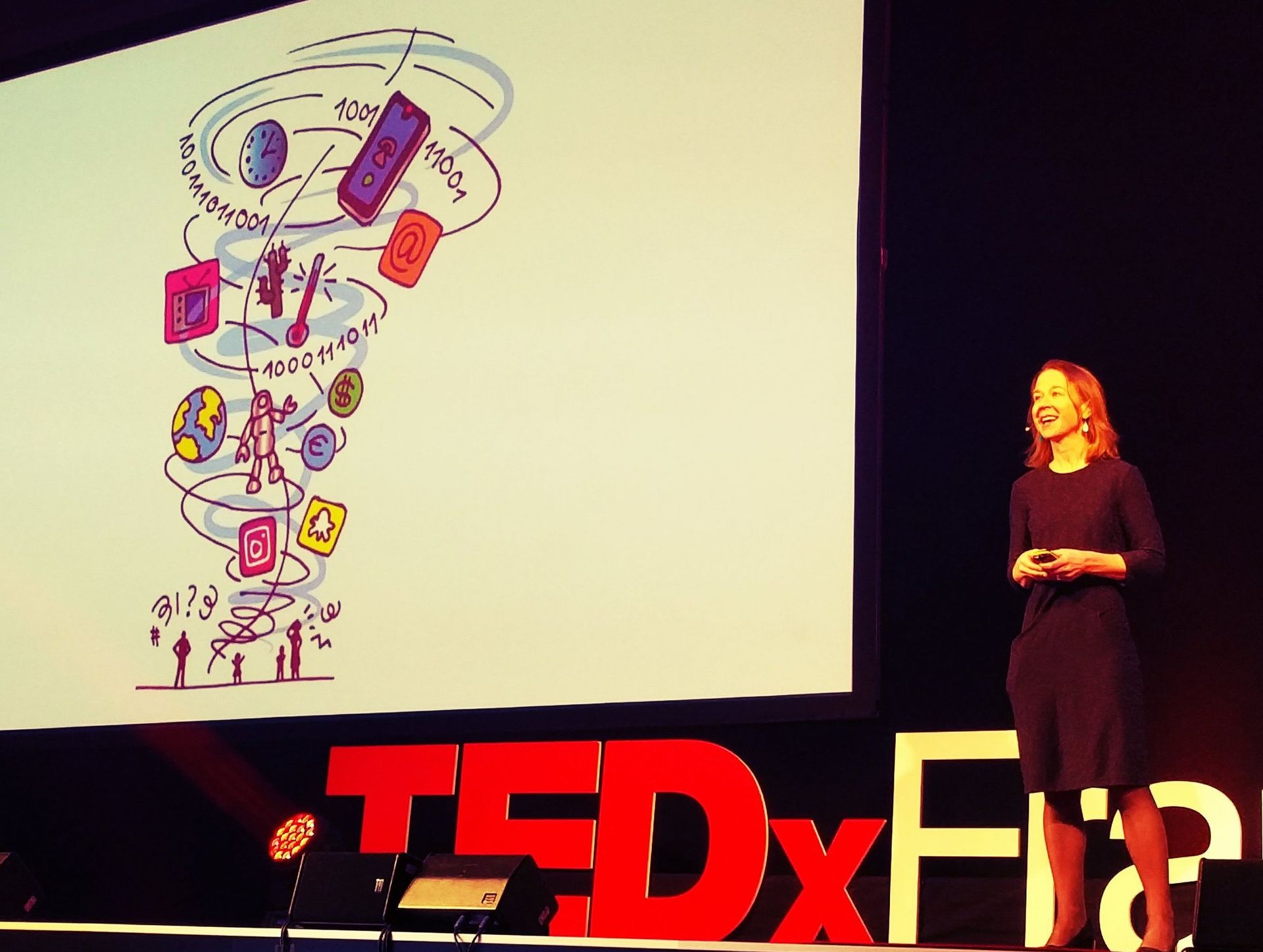 April Rinne stands on a TEDx stage