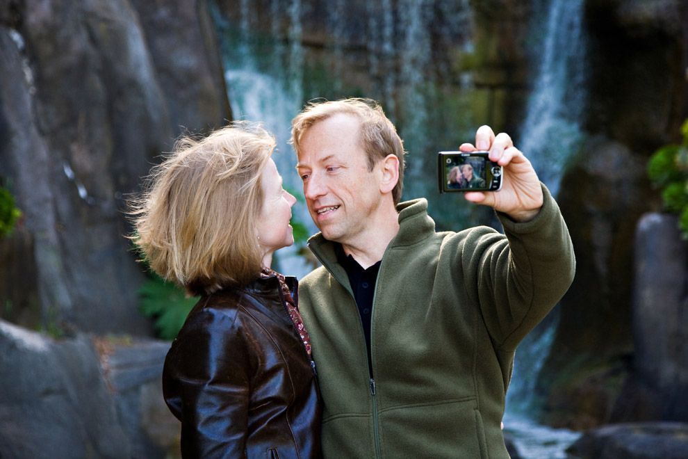 Jerry Michalski and April Rinne are taking a selfie in front of a waterfall.