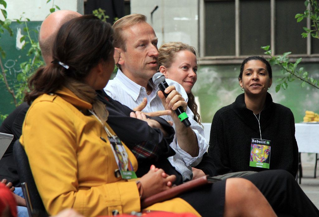 Jerry Michalski is holding a microphone in front of a group of people