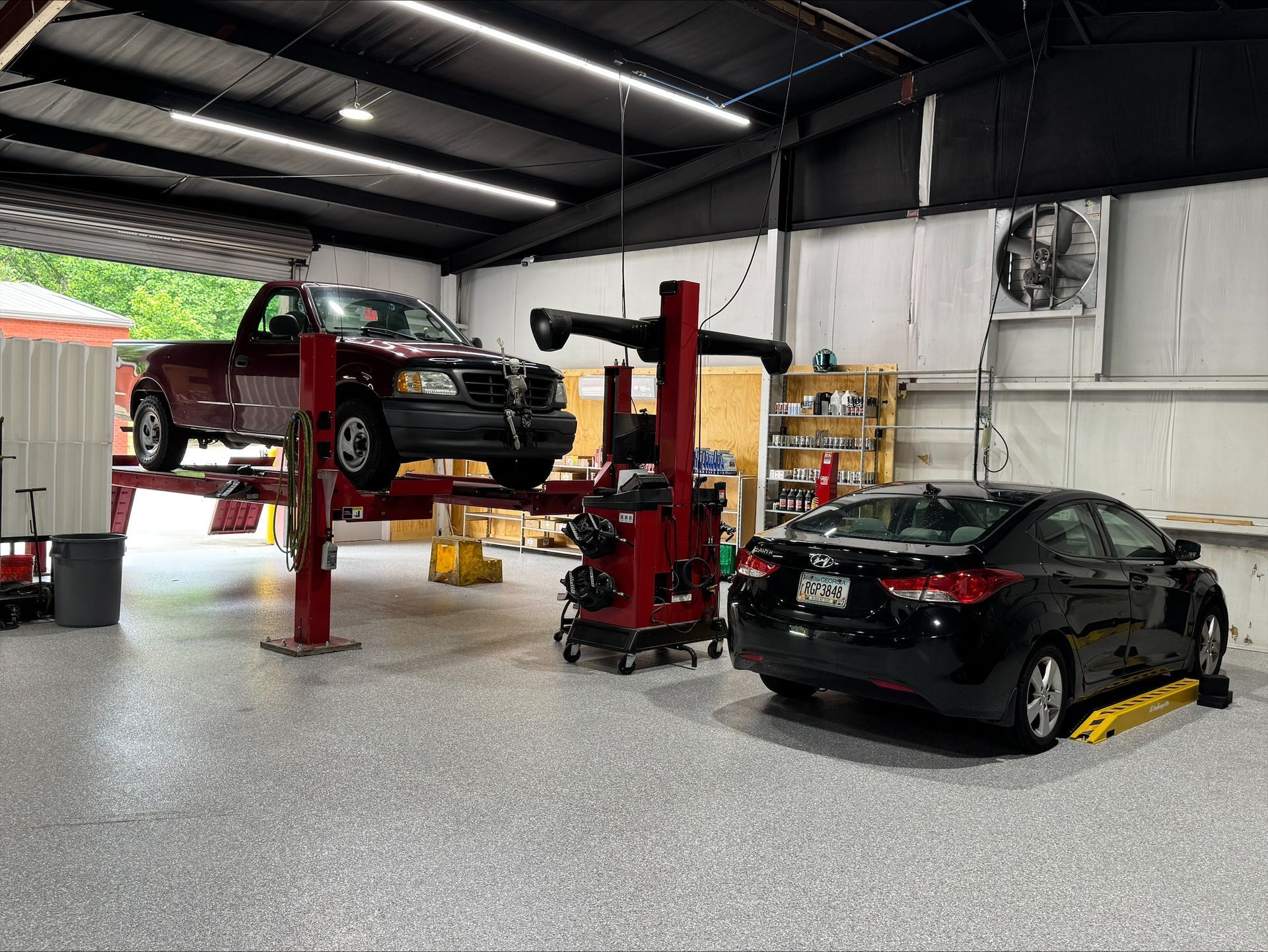 A Red Pick-up Truck on a Lift in Our Garage at Marietta Auto Repair