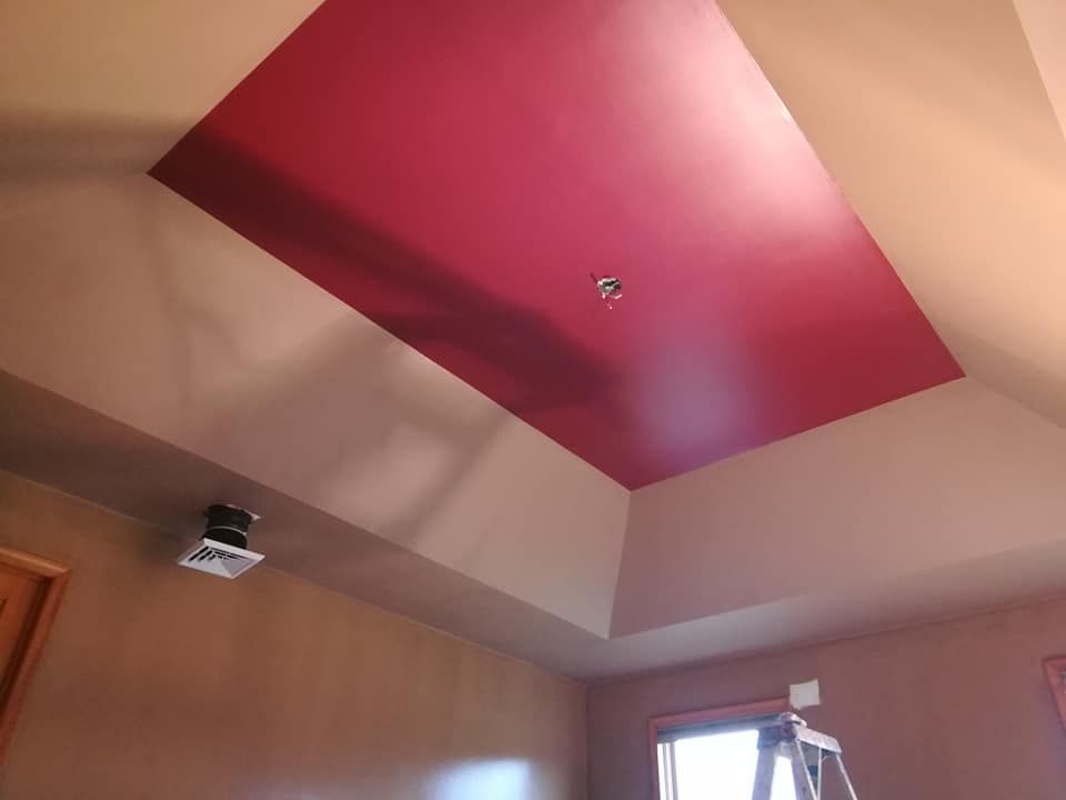 Angled ceiling painted red, surrounded by tan walls. A vent and light fixture are visible.