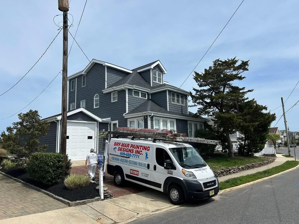 White plumbing van parked in front of a gray house. A worker walks toward the house.