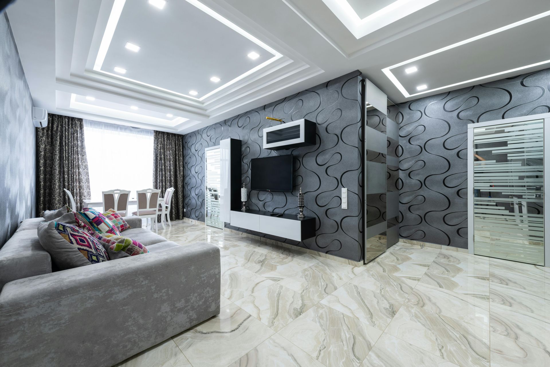 Living room with gray sofa, patterned wallpaper, marble floor, and recessed ceiling lights.