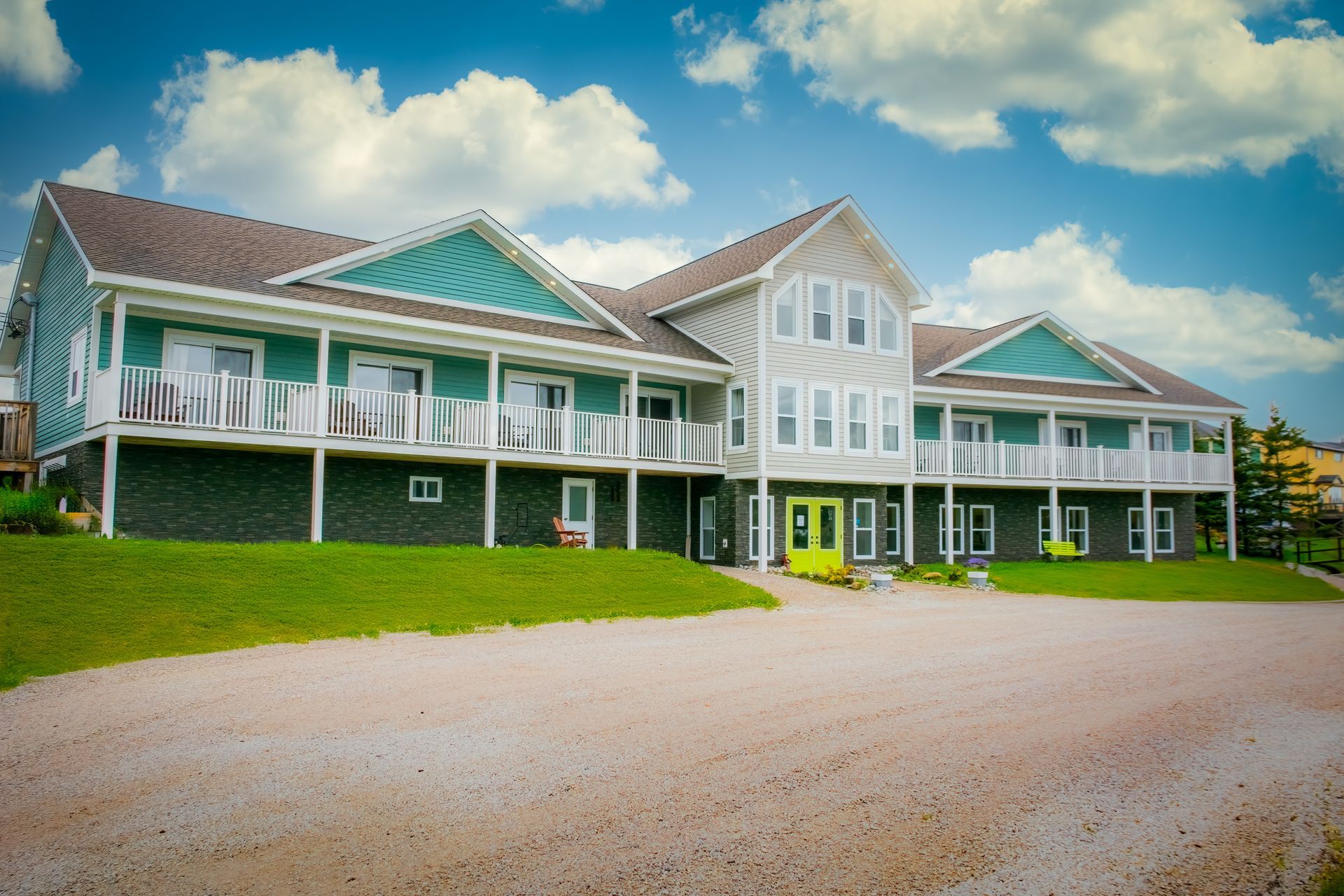 A large green and white house with a yellow door