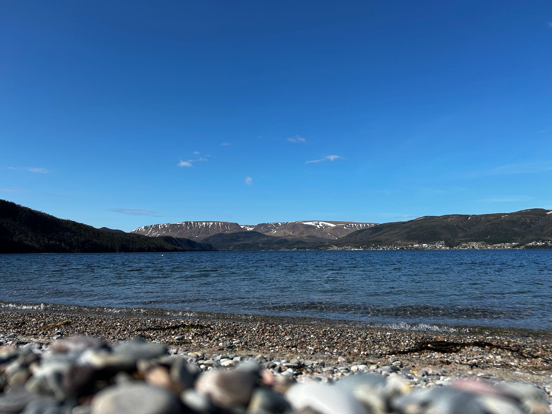 A lake with mountains in the background and rocks in the foreground