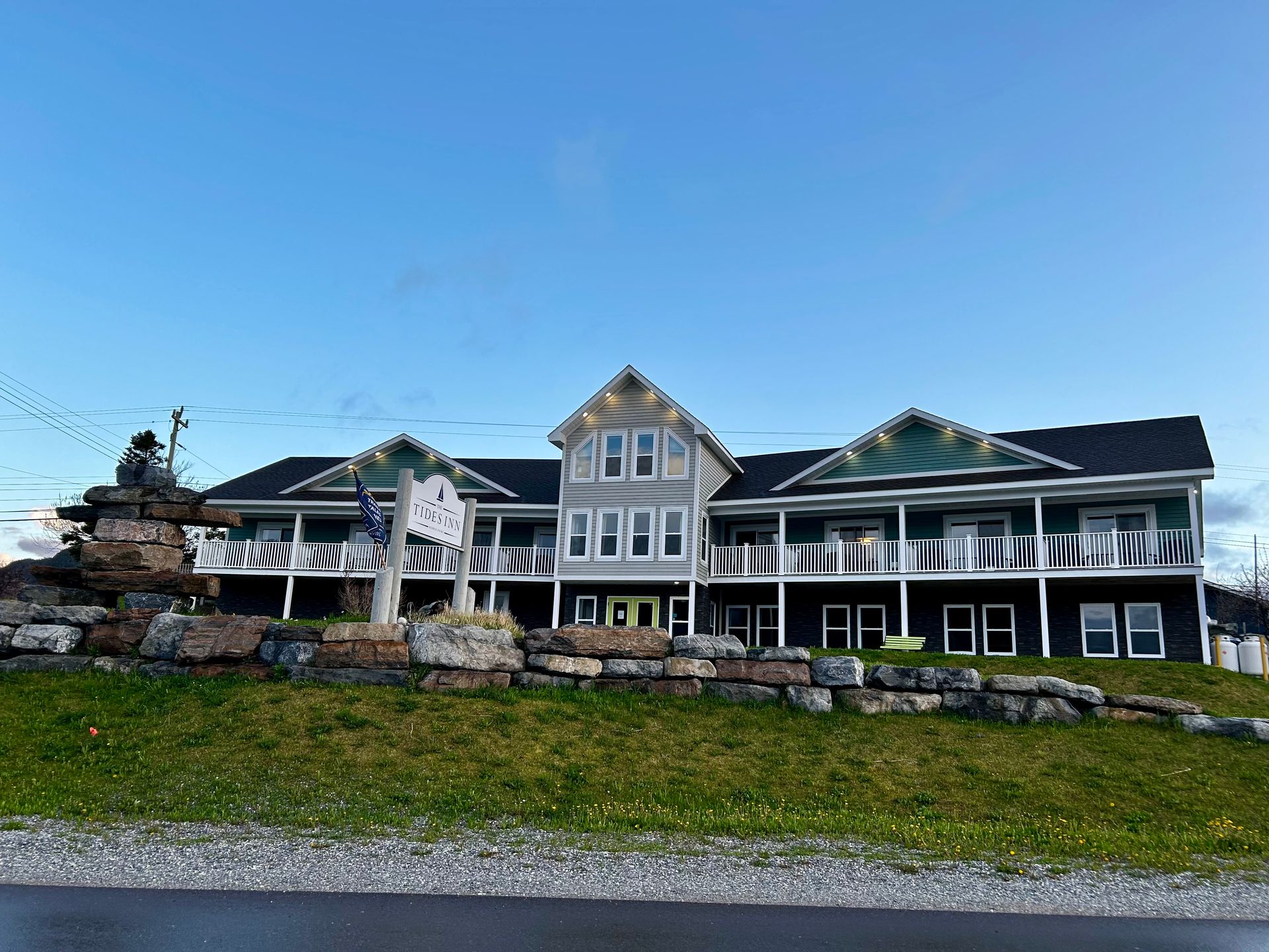 A large house is sitting on top of a grassy hill.