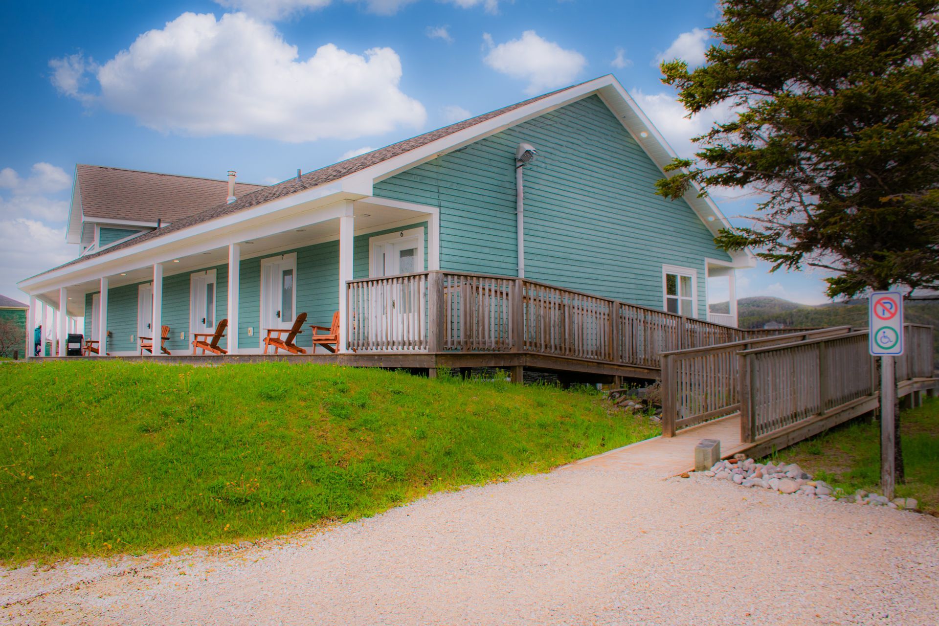A blue house with a large porch and a no parking sign