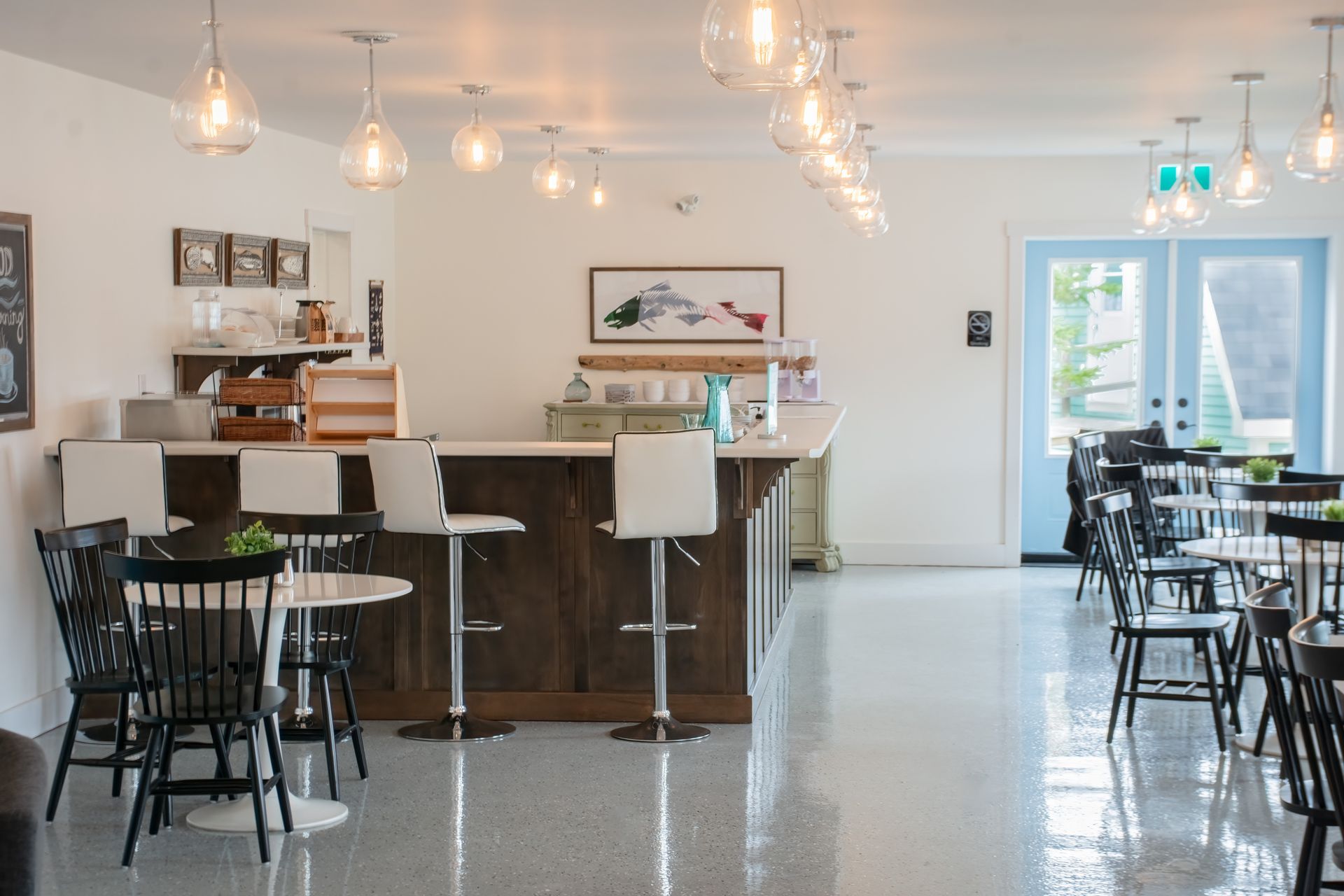 A restaurant with tables and chairs and a bar.