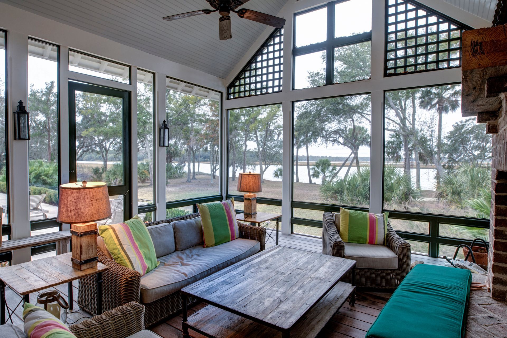 A screened in porch with a lot of windows and furniture