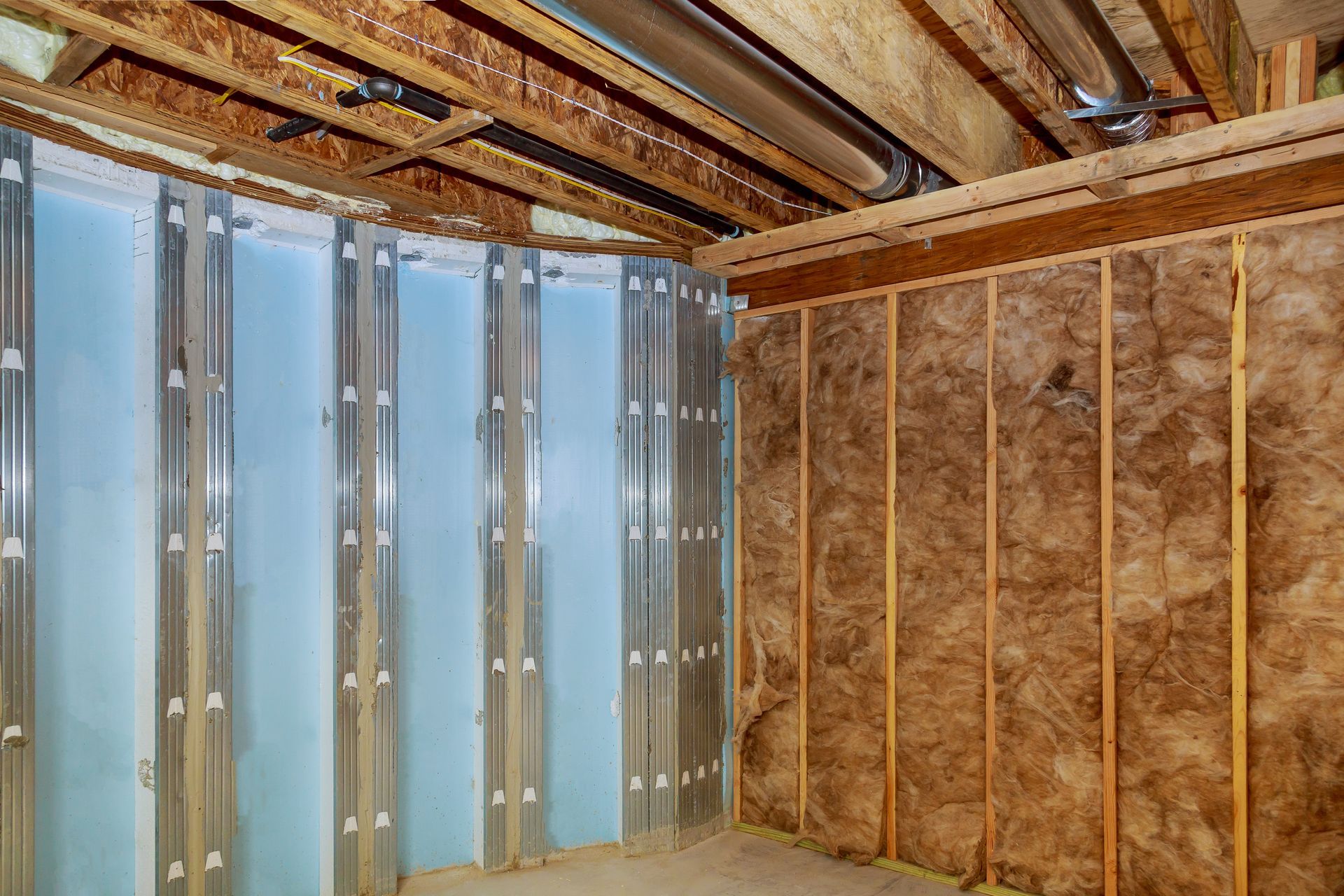 A basement with insulation on the walls and ceiling.