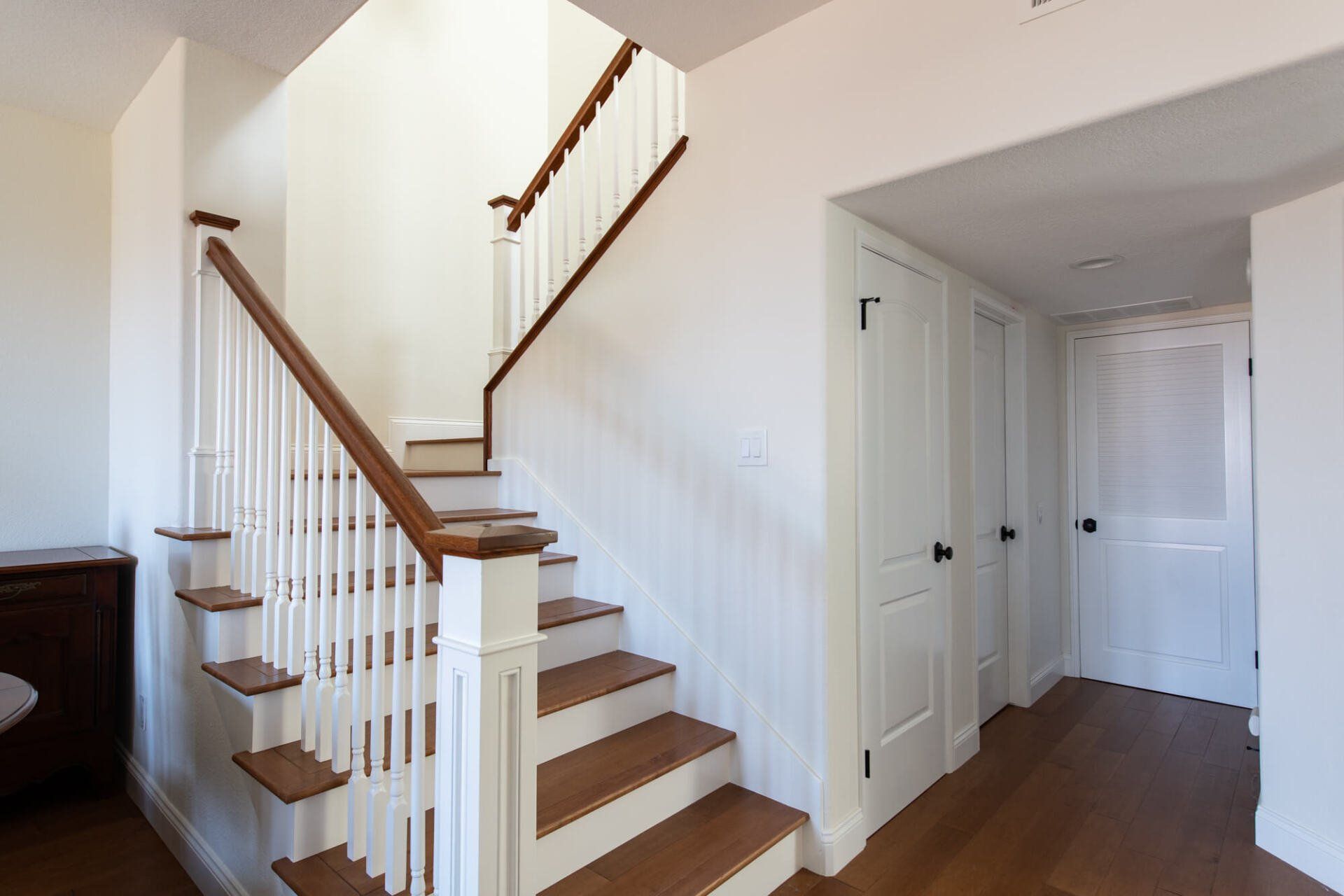 A wooden staircase with white railings in a hallway
