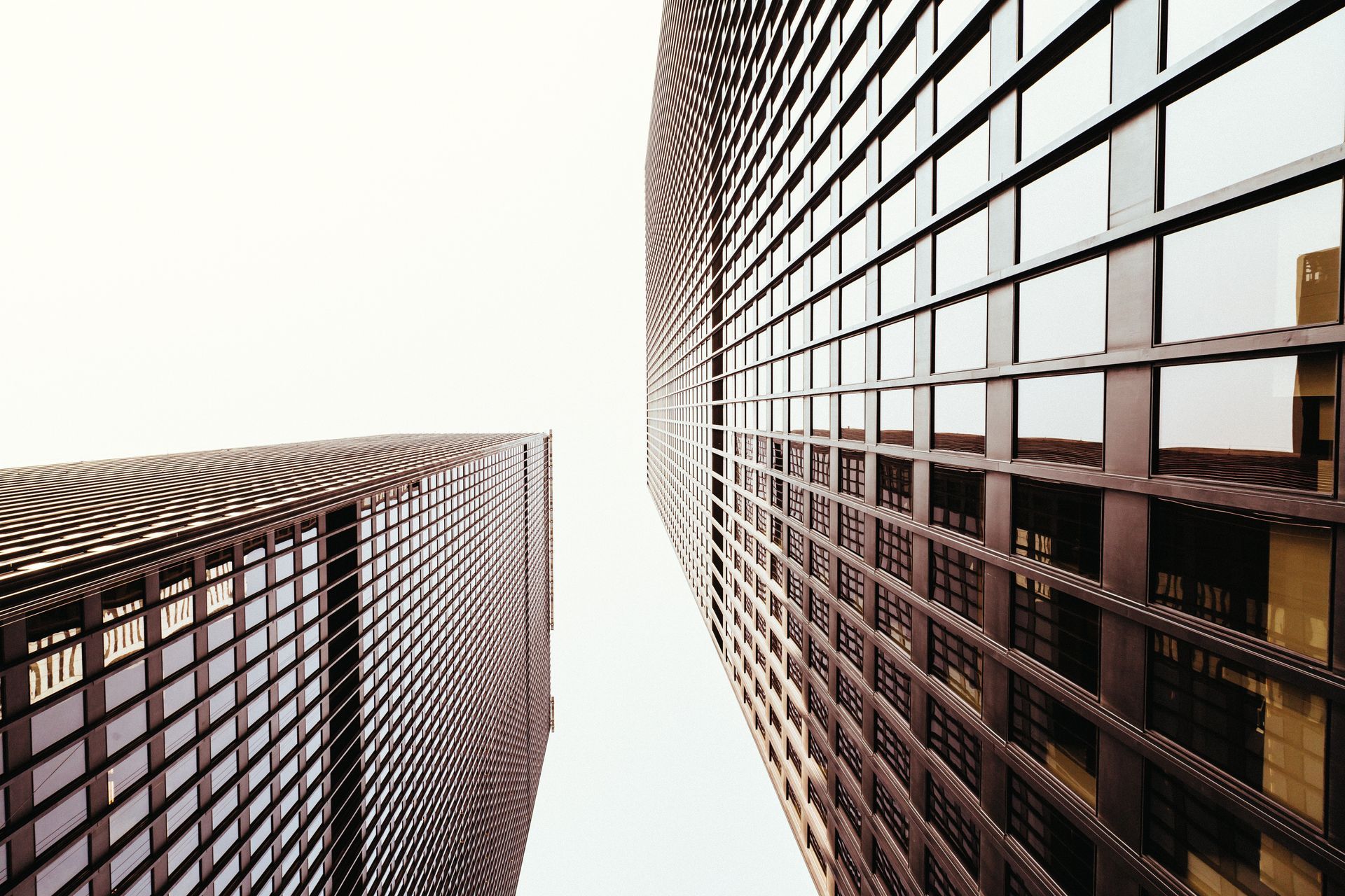 Looking up at a tall building with a lot of windows on a white background.