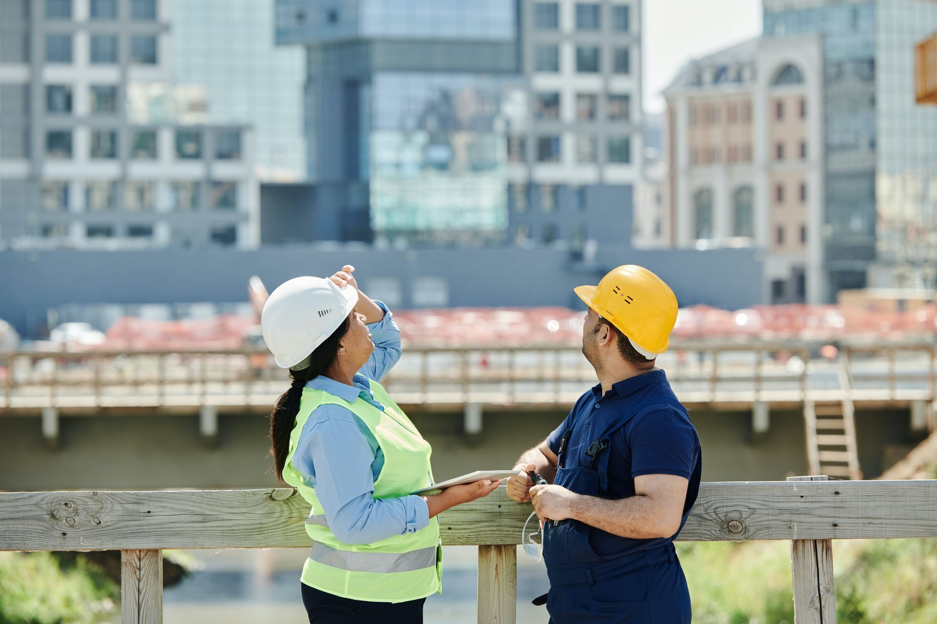 A man and a woman are standing next to each other on a bridge.