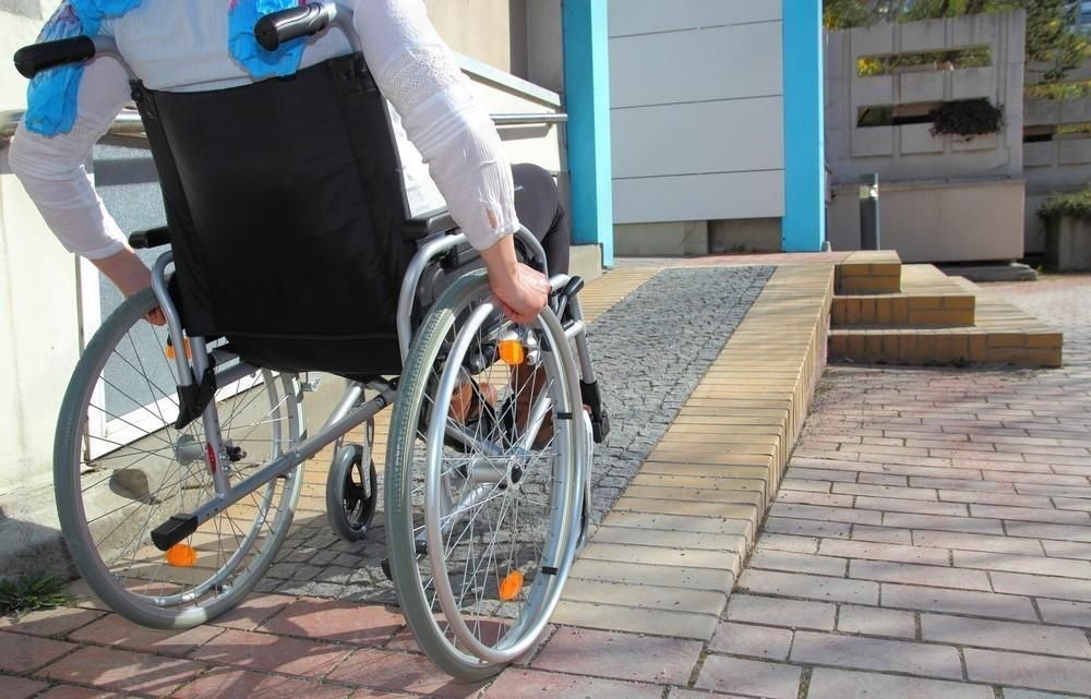 A person in a wheelchair is going down a ramp.