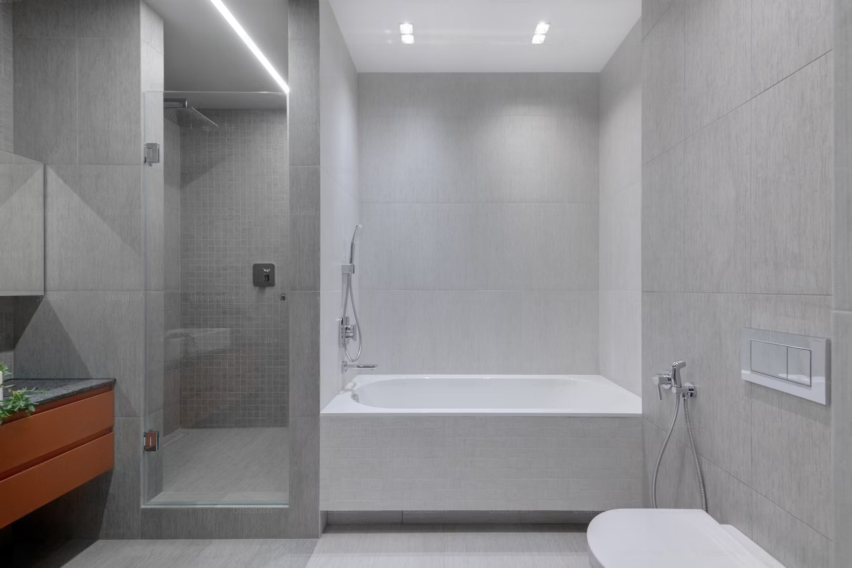 A bathroom with a bathtub , toilet , shower and mirror.