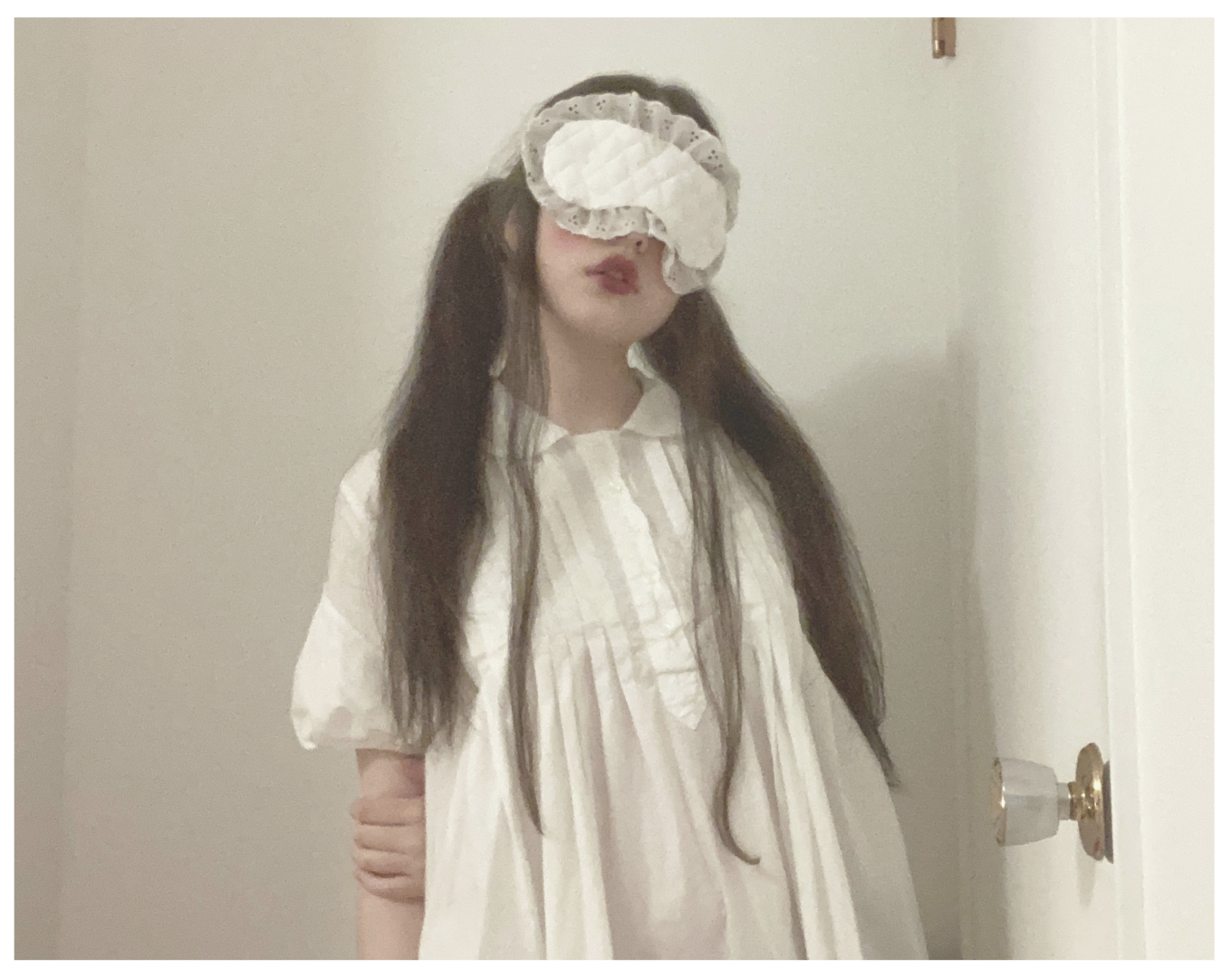 A girl in a white dress with a sleep mask on her eyes, from the work 
