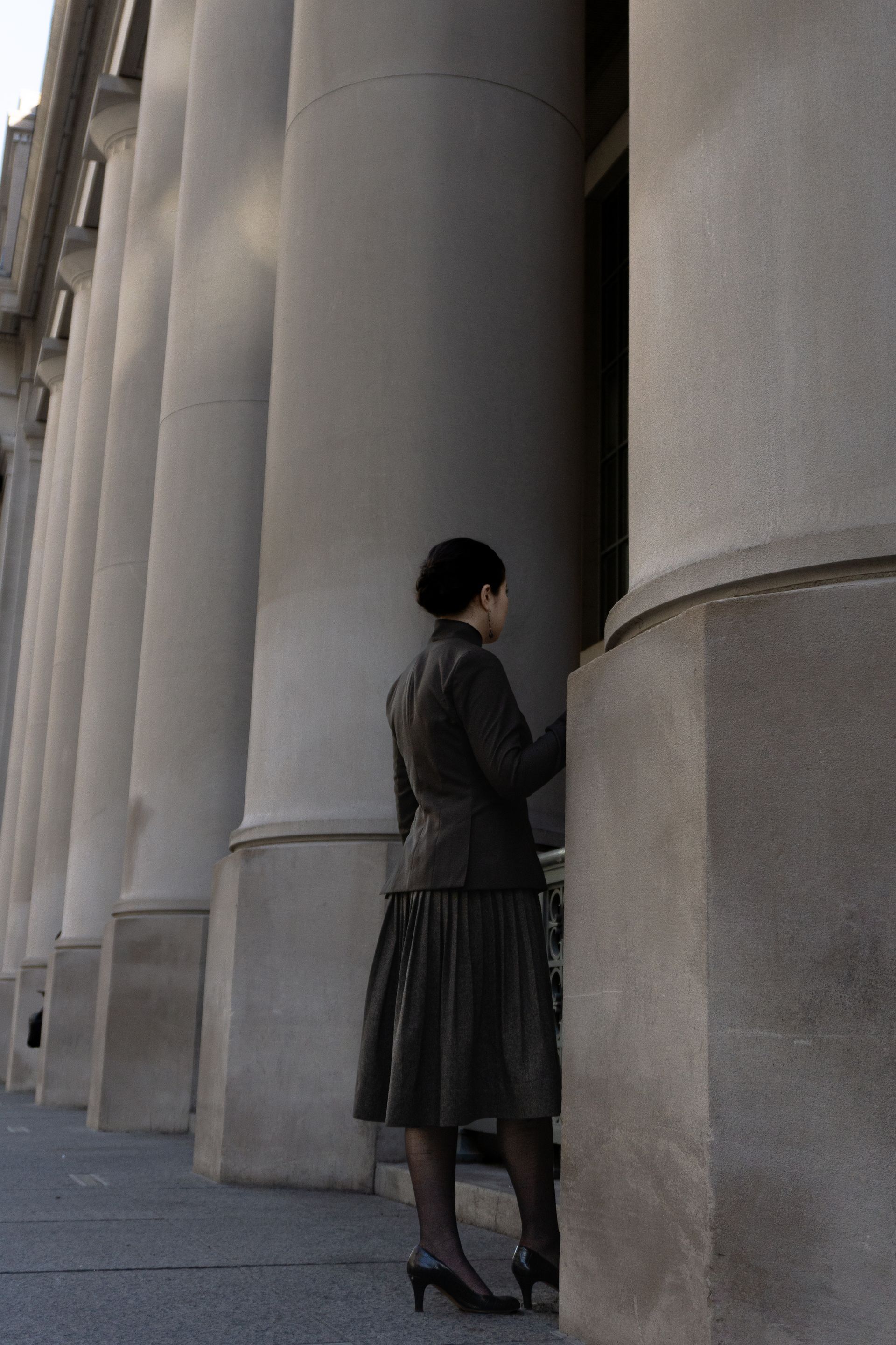 A woman in a suit standing in front of the ionic pillars at Union Station.