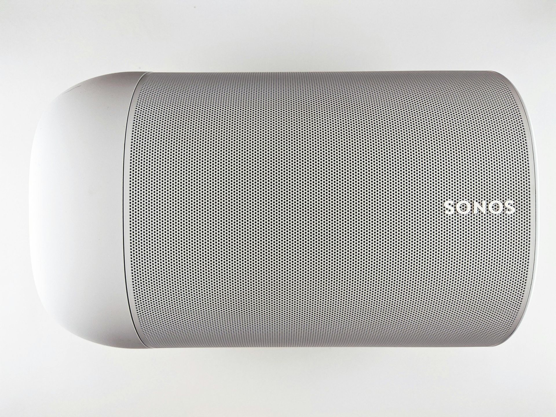 White Sonos speaker with a curved grill and the