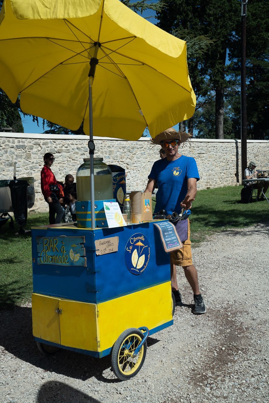 Un homme se tient devant un chariot avec un parapluie jaune.