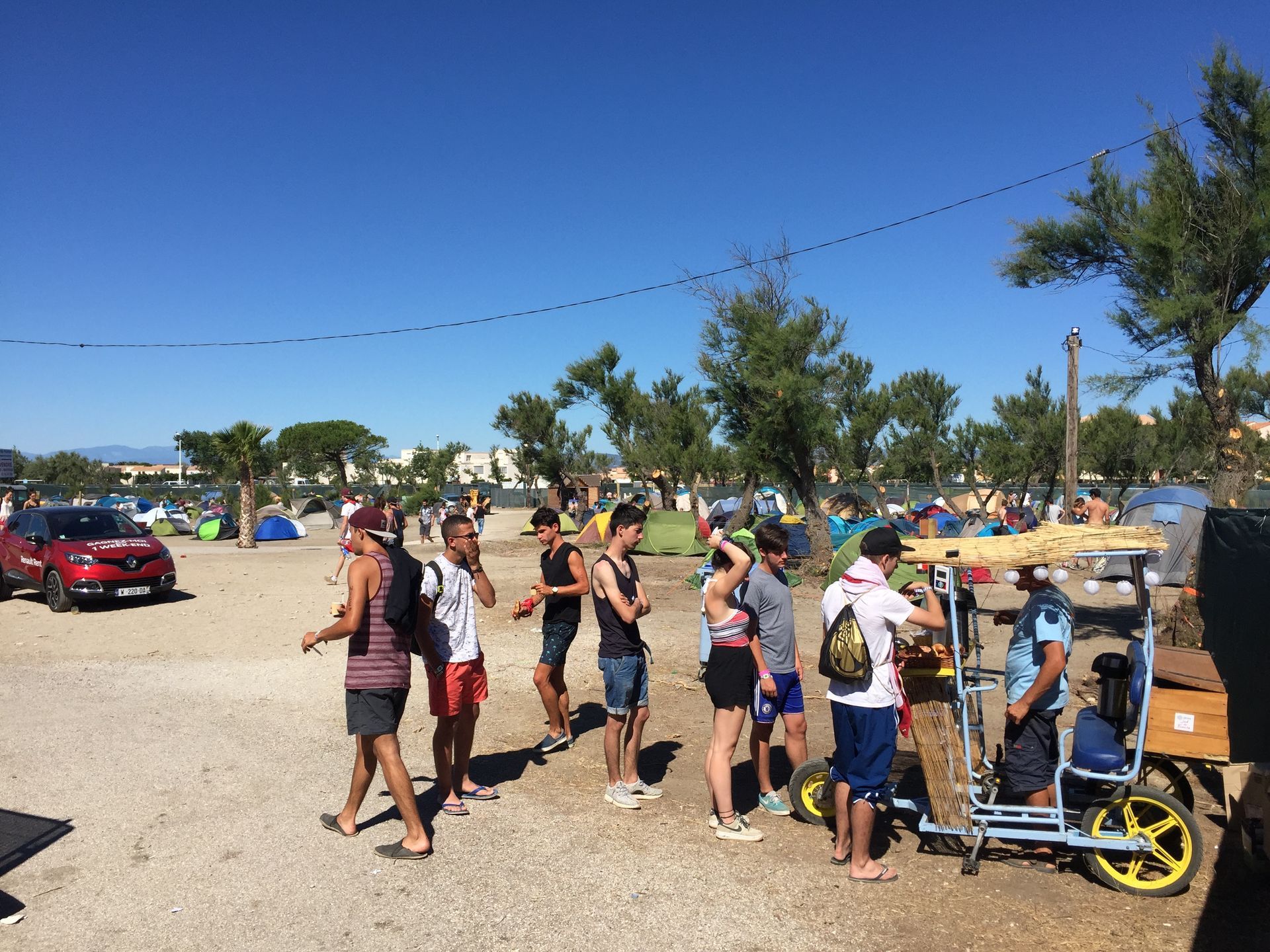 Un groupe de personnes se tient debout sur un parking.