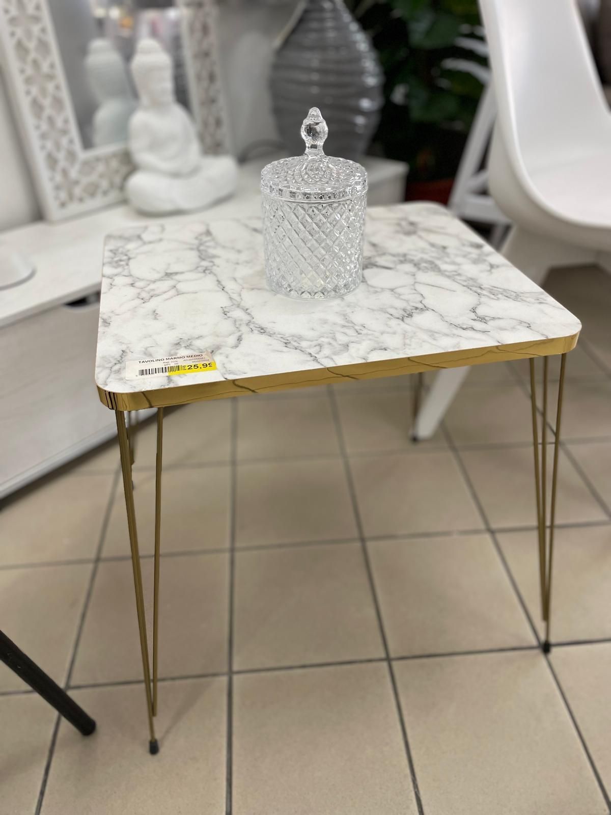Un tavolino con piano in marmo e gambe a forcina dorate.