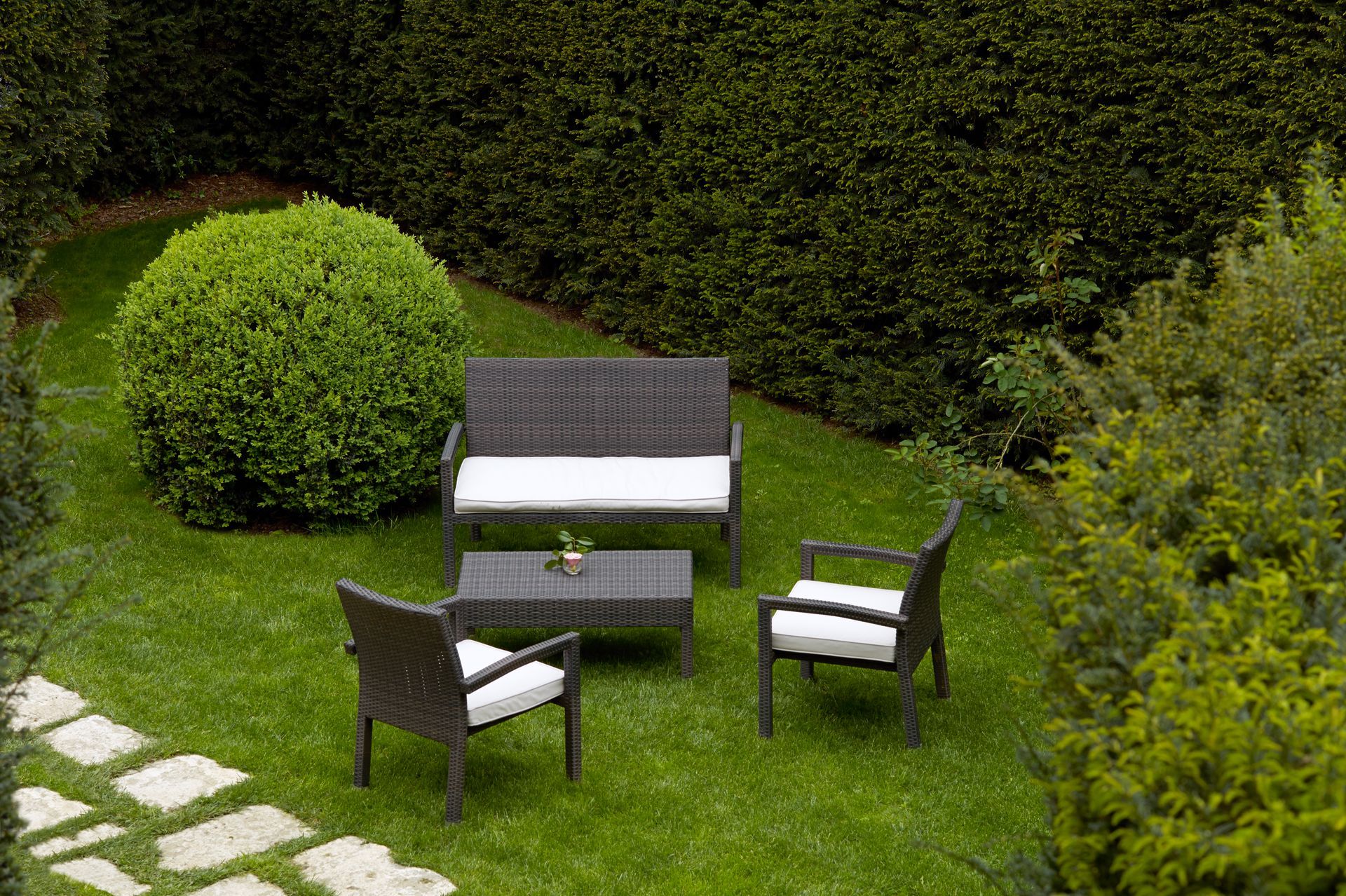 Un prato con un divano, sedie e un tavolo