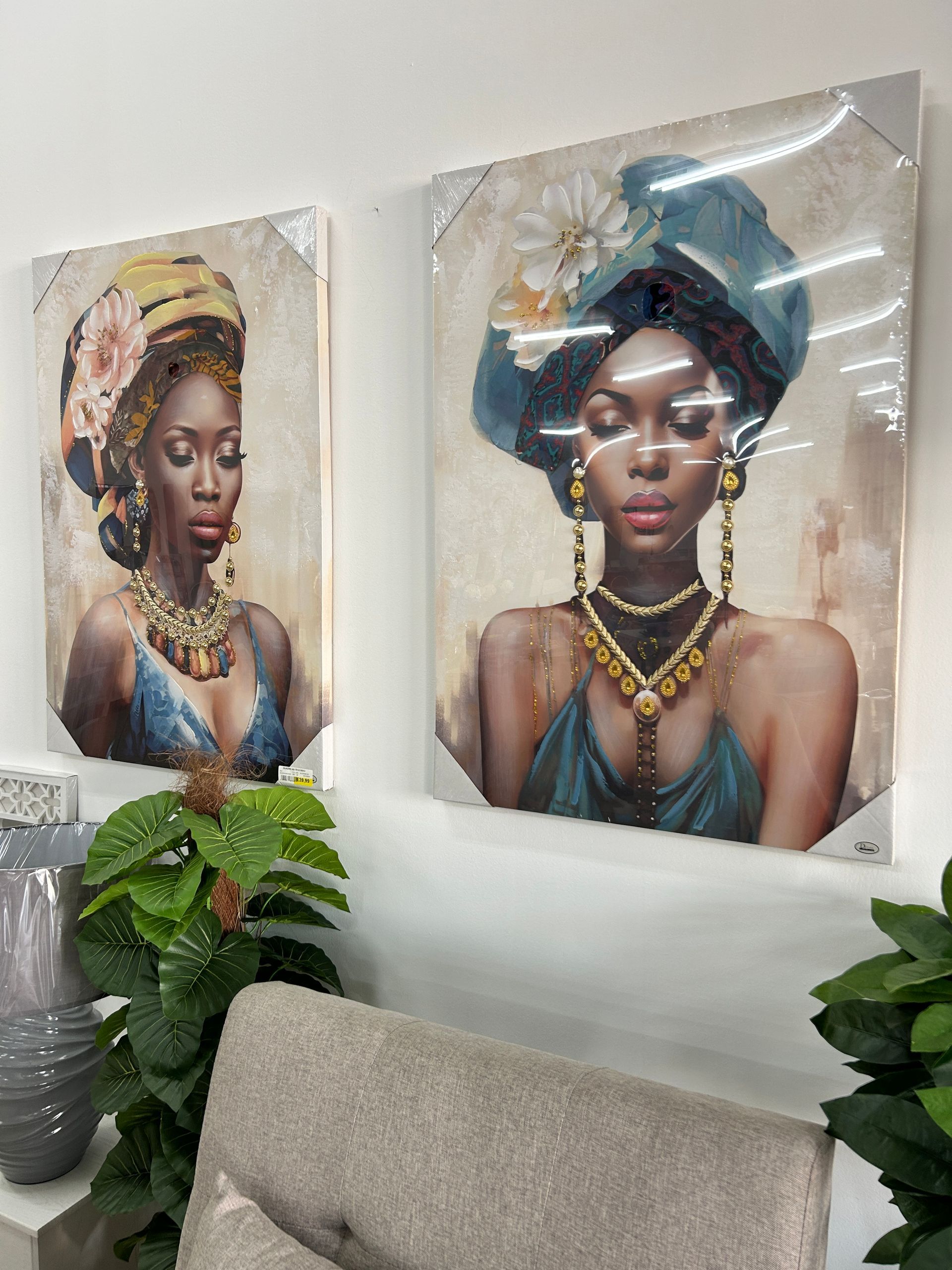 Due dipinti di donne africane sono appesi su una parete in un soggiorno.