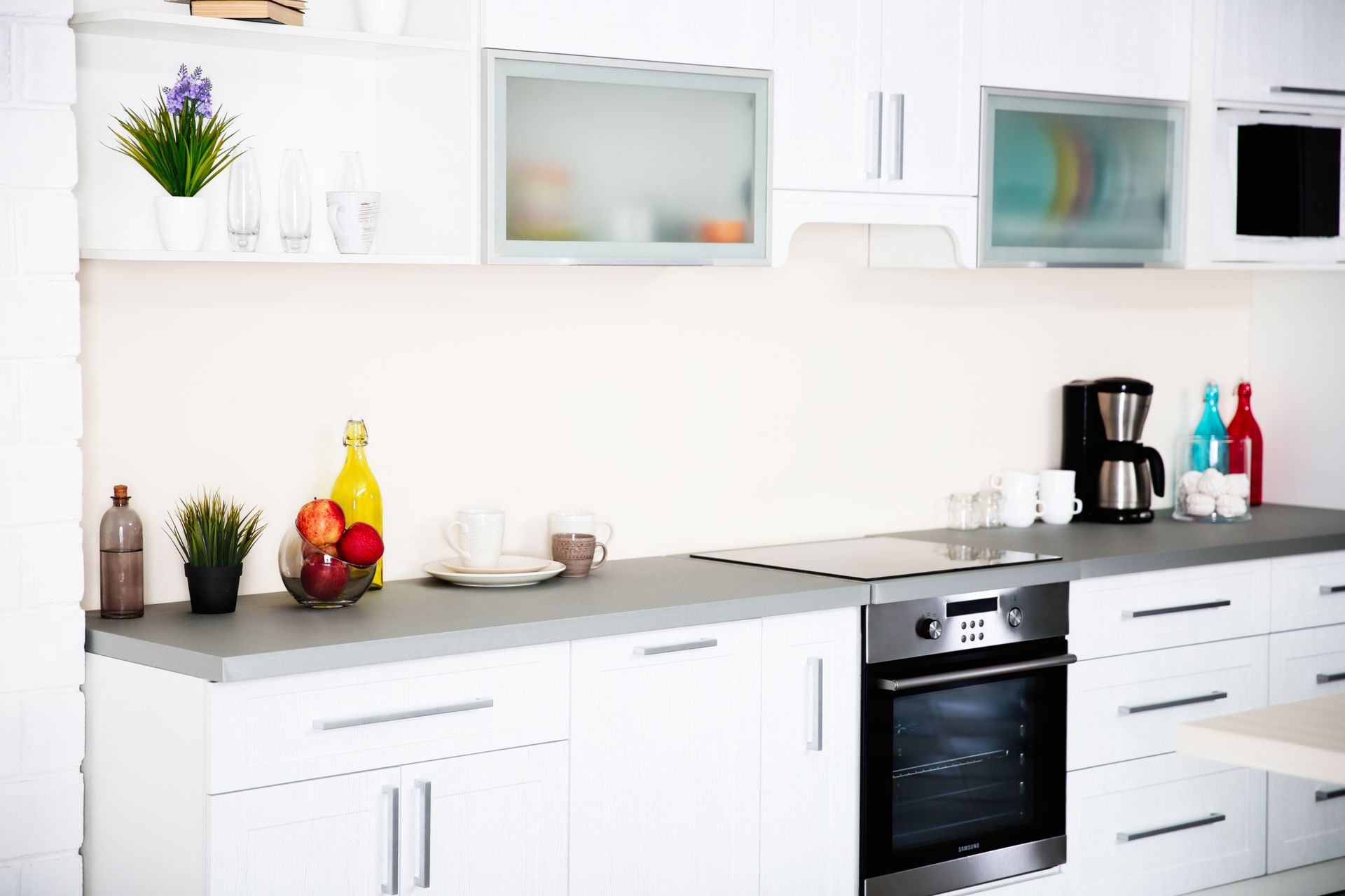 Una cucina con mobili bianchi ed elettrodomestici in acciaio inossidabile