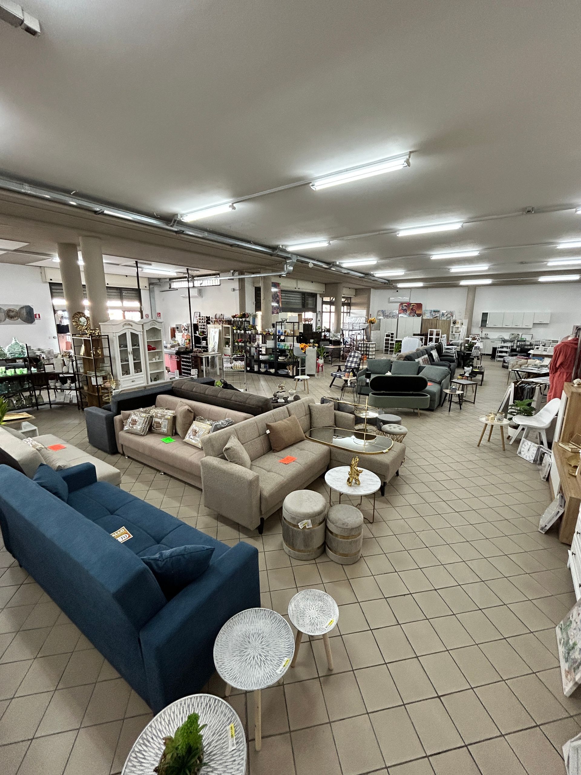 Una grande stanza piena di mobili e tavoli.