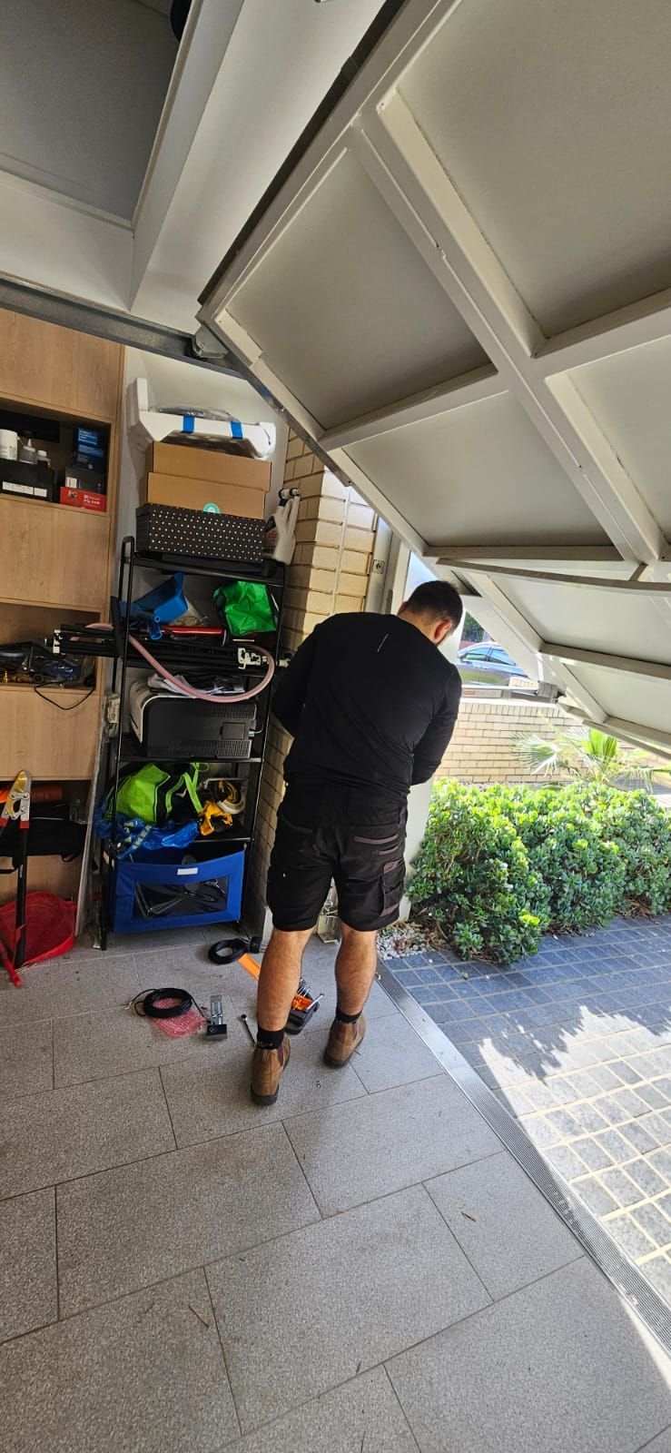 A man is working on a garage door in a garage.