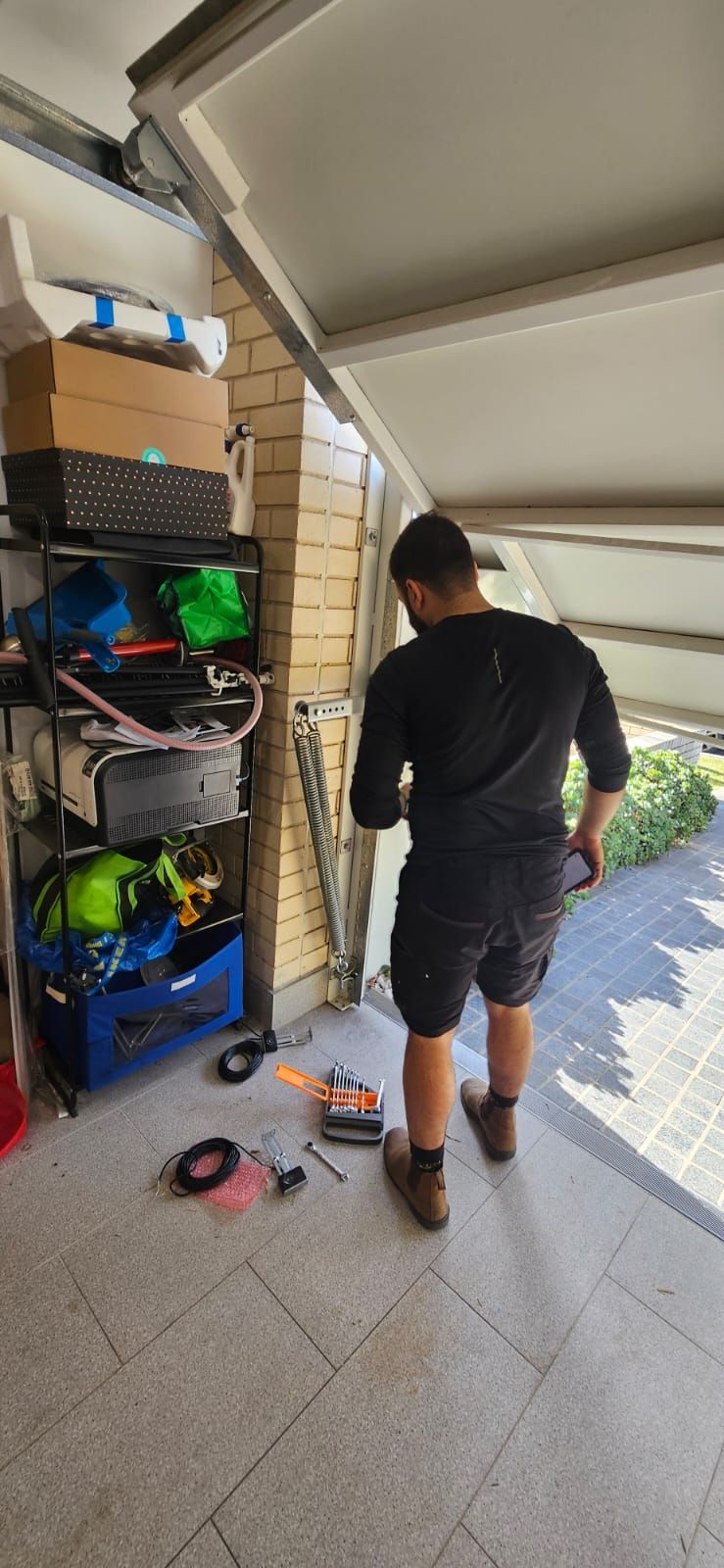A white house with blue garage doors and a driveway
