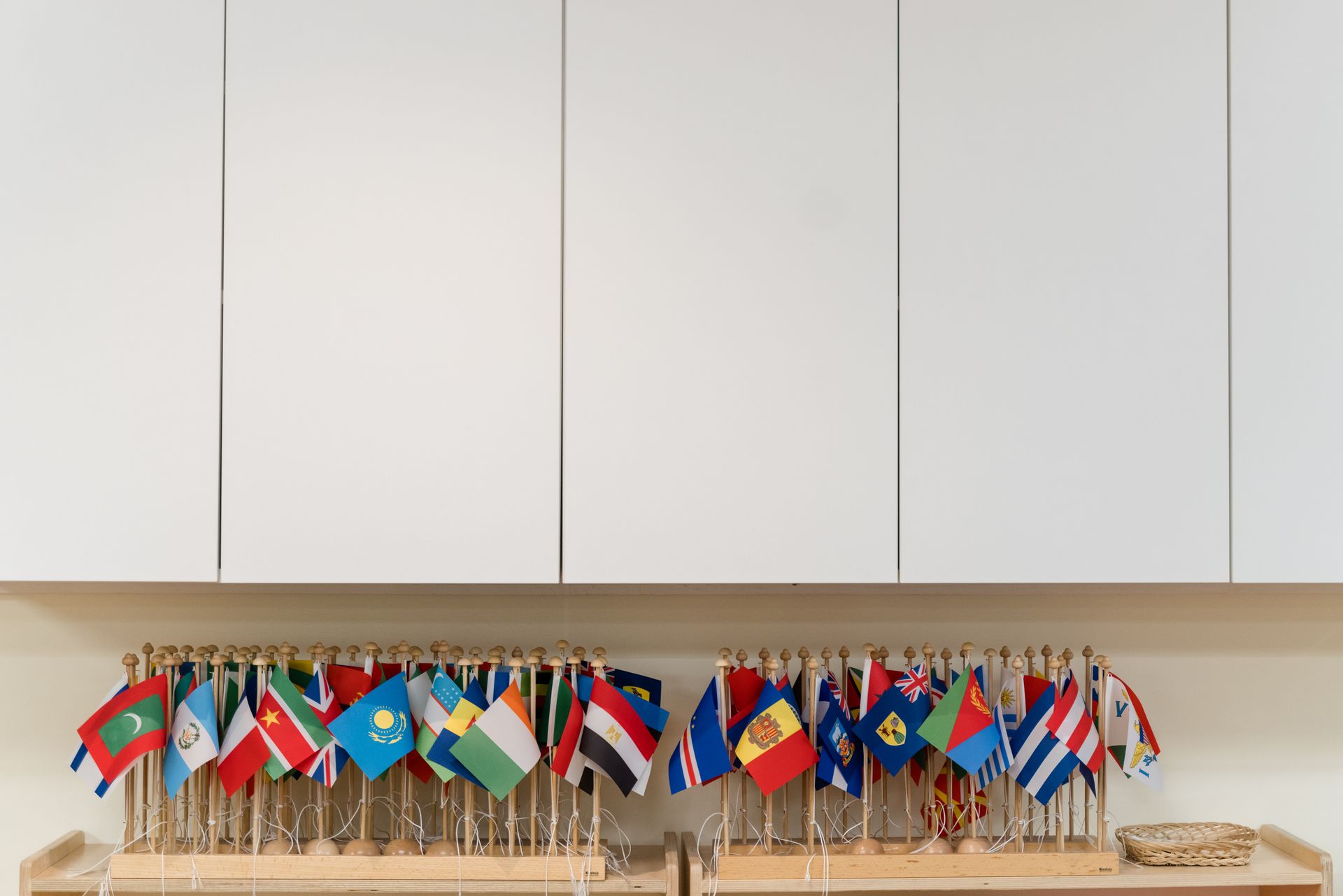 A bunch of flags are on a rack on a wall.