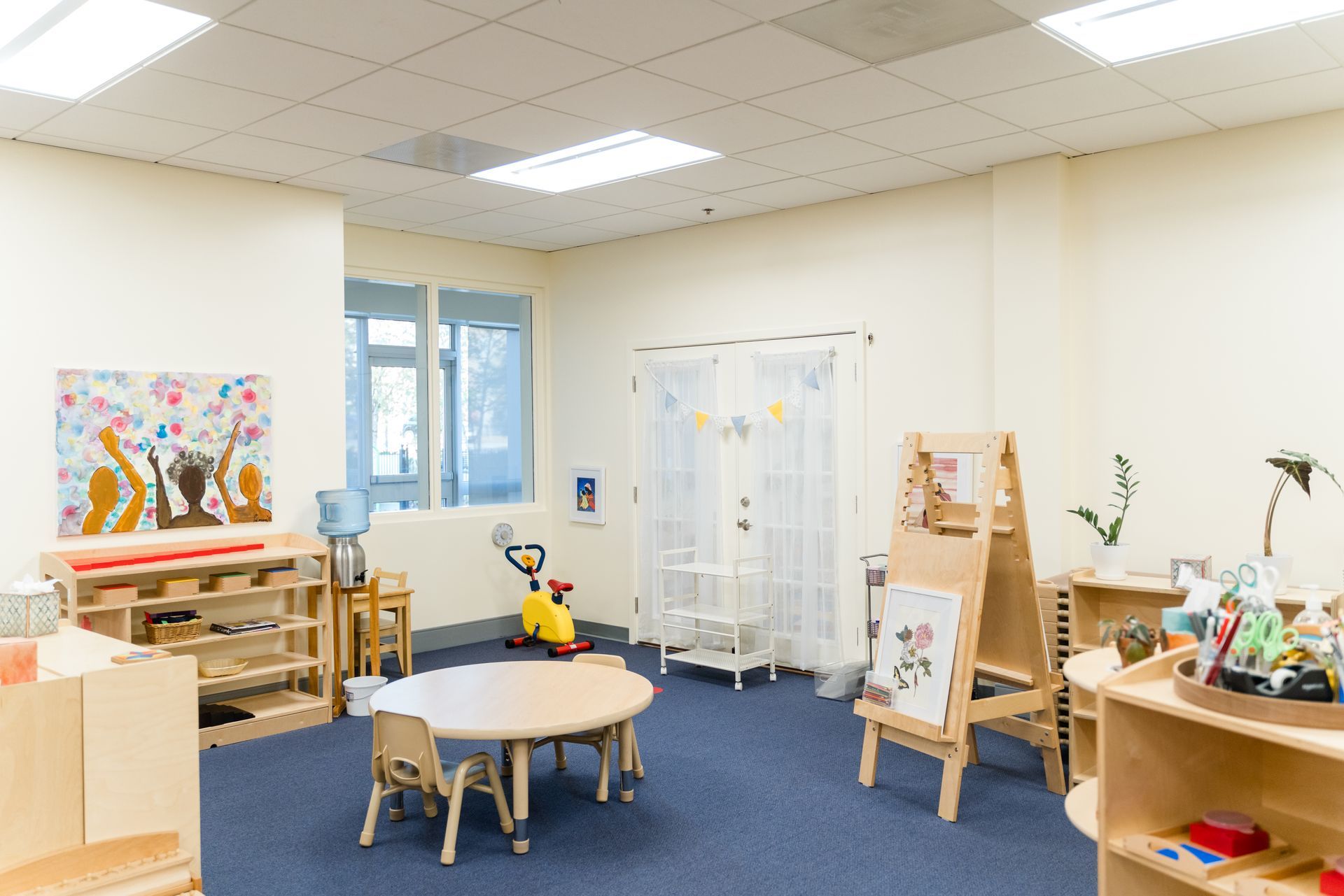 A montessori classroom with a table and chairs in it.