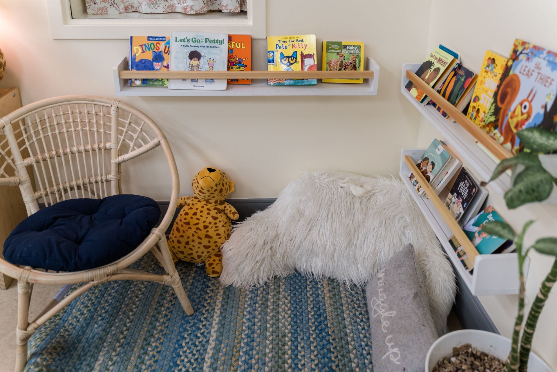 Montessori classroom corner with a chair and a bookshelf filled with books.