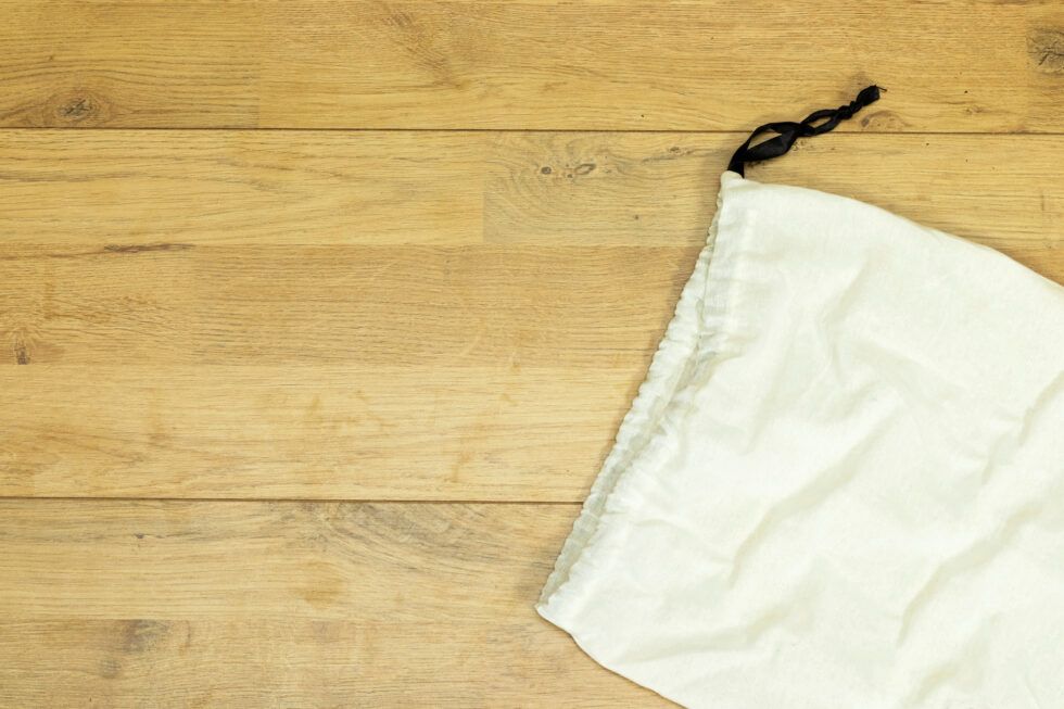 A white bag is sitting on a wooden table