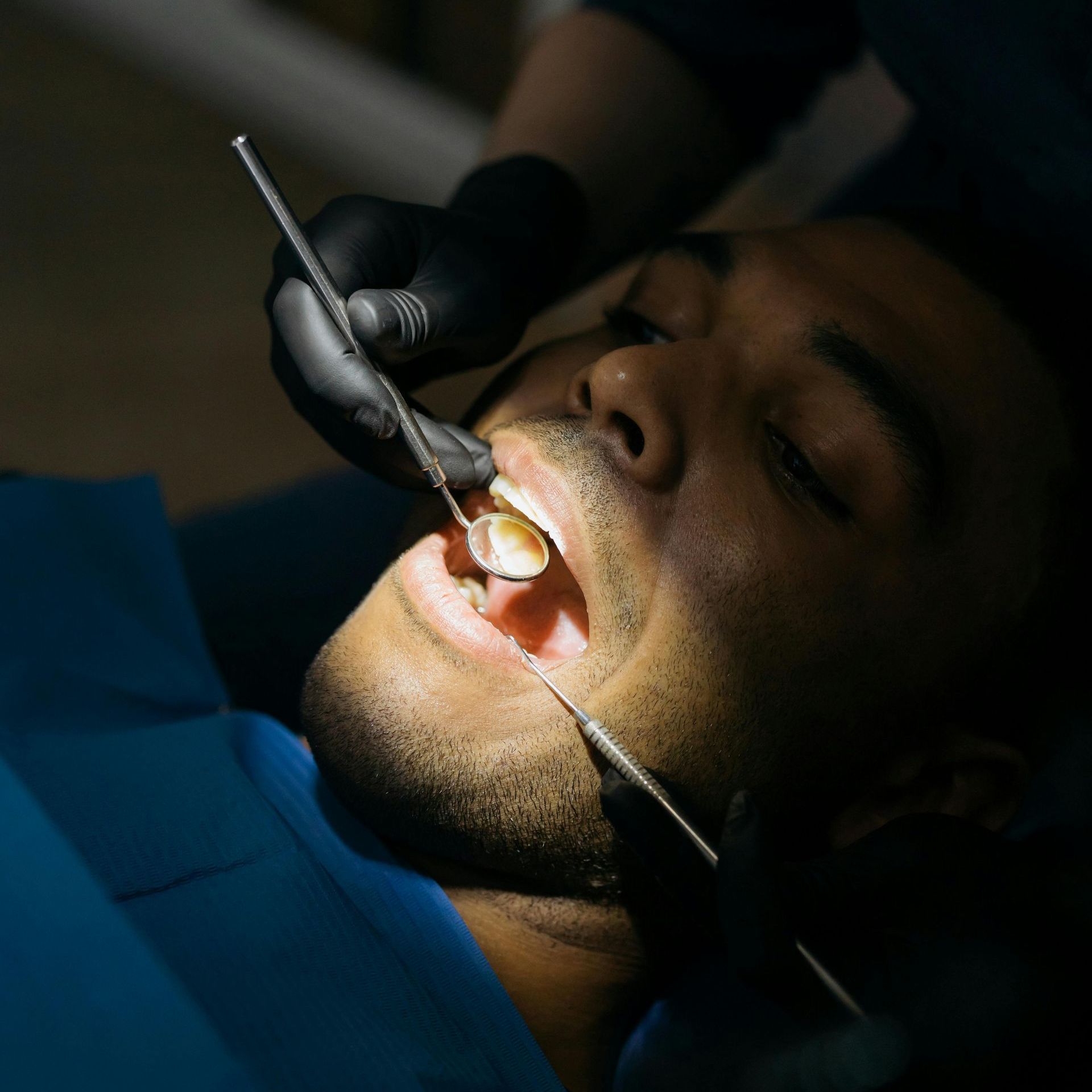 A man is getting his teeth examined by a dentist.