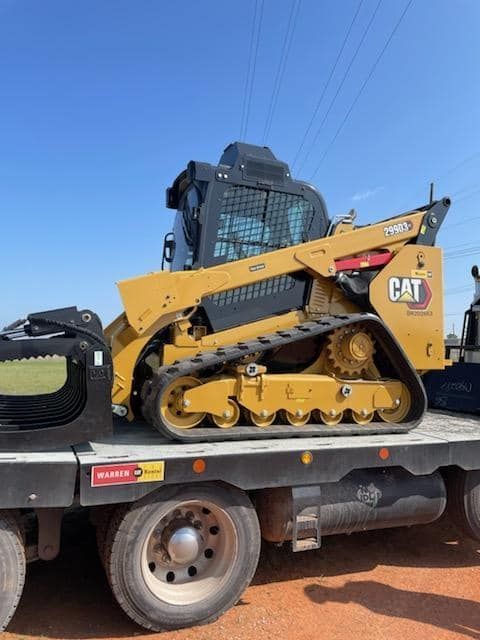 A cat bulldozer is sitting on top of a flatbed truck.