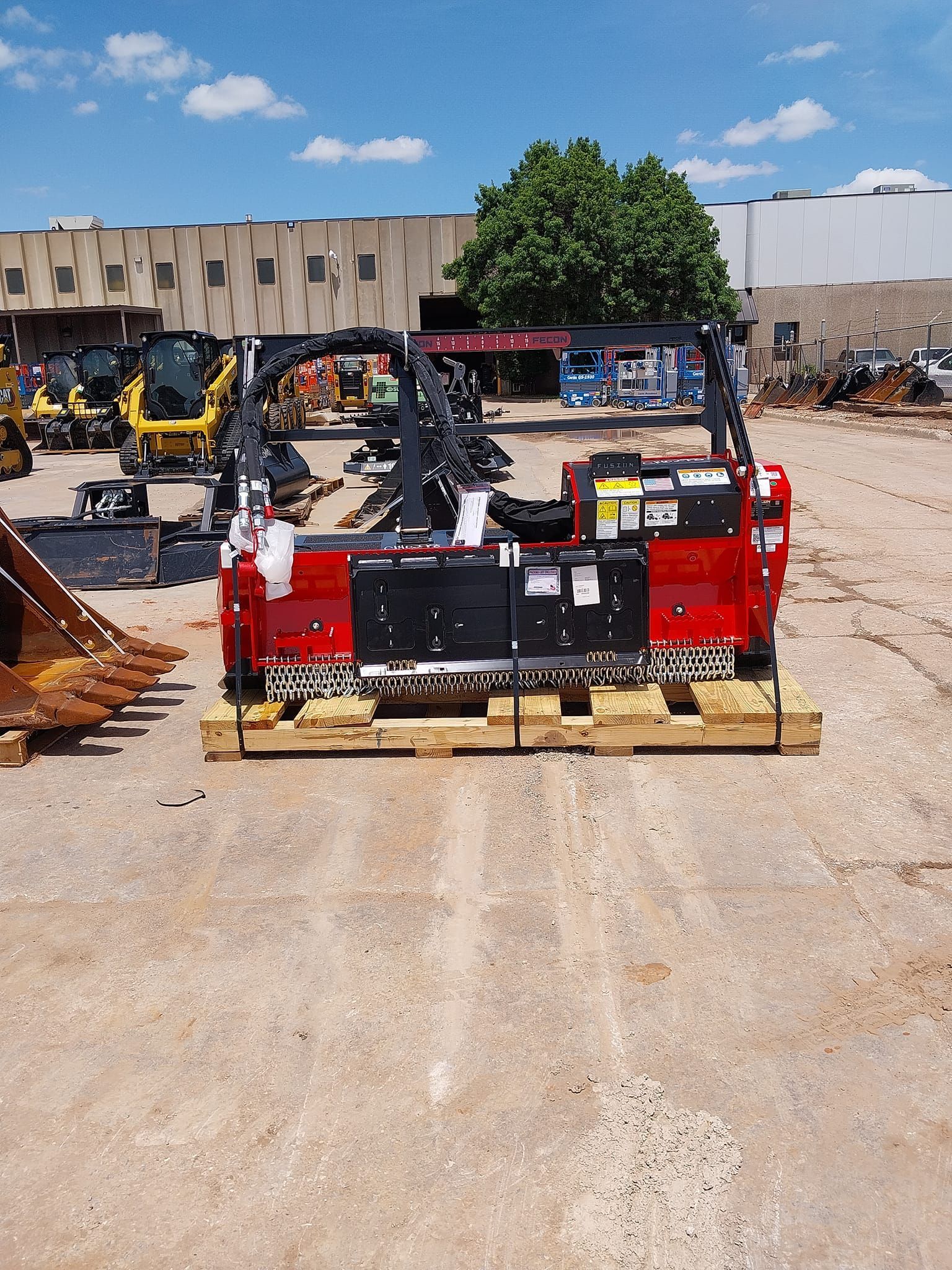 A red truck is sitting on a wooden pallet in front of a building