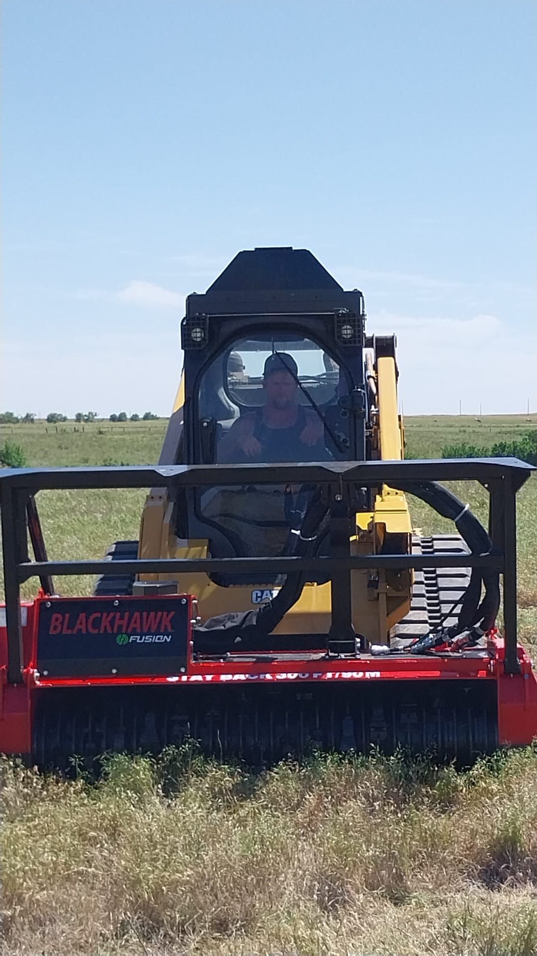 A man is driving a bulldozer in a field.