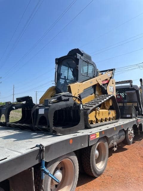 A bulldozer is sitting on top of a flatbed truck