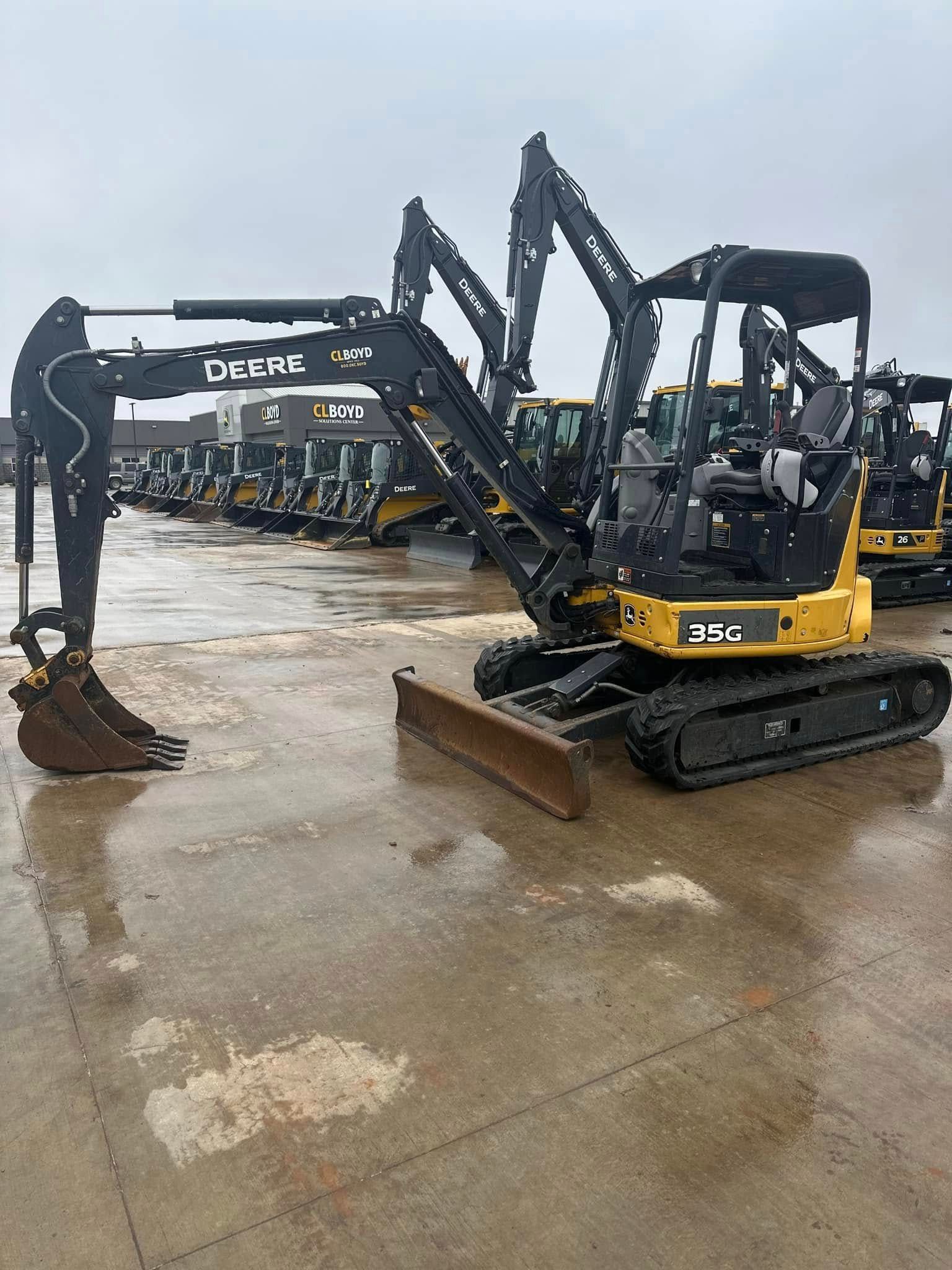 A yellow and black excavator is parked in a parking lot.
