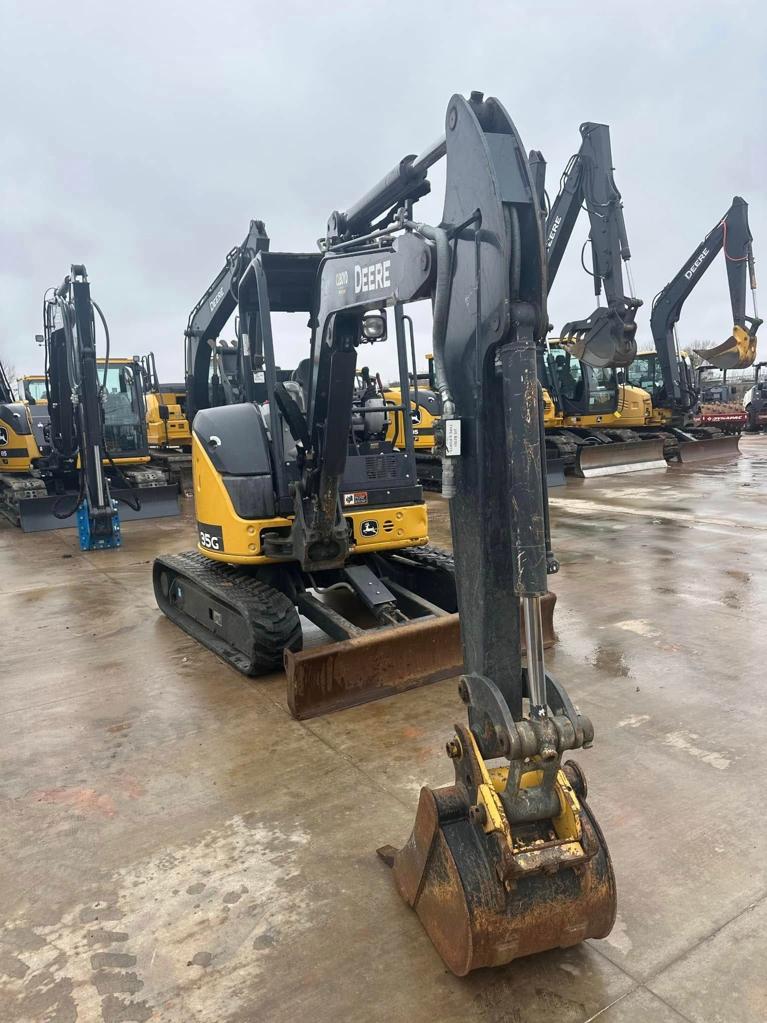 A yellow and black excavator is parked in a parking lot.