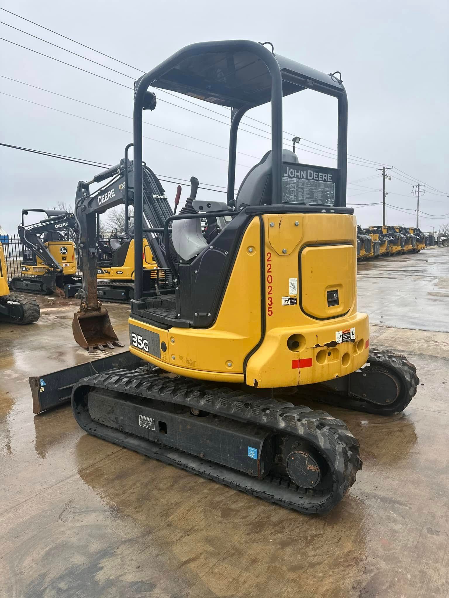 A yellow and black excavator is parked in a parking lot.