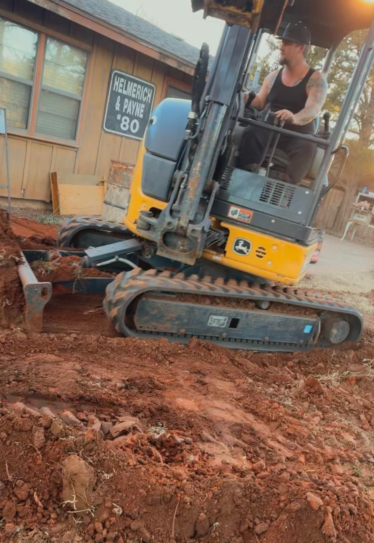 A man is driving a bulldozer on a dirt road.